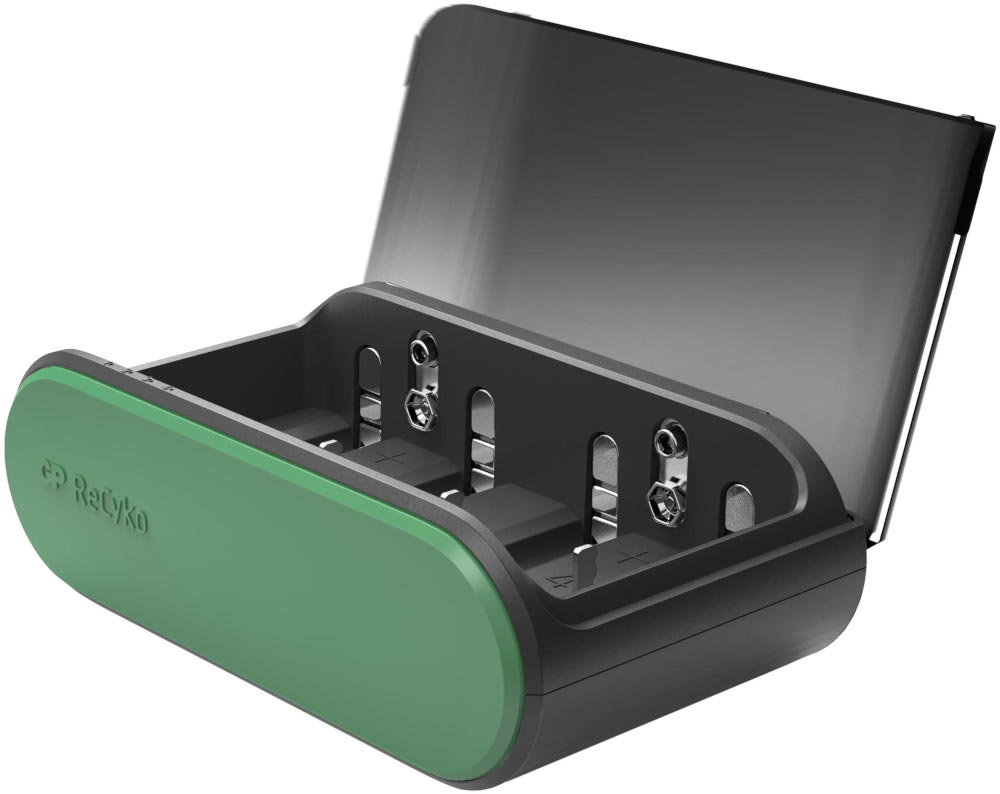 Un chargeur de batterie ouvert, vert et noir, avec des batteries à l'intérieur.