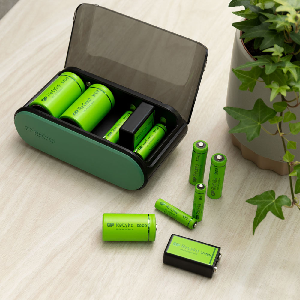 Un étui de chargement contenant plusieurs piles rechargeables vertes et des supplémentaires.