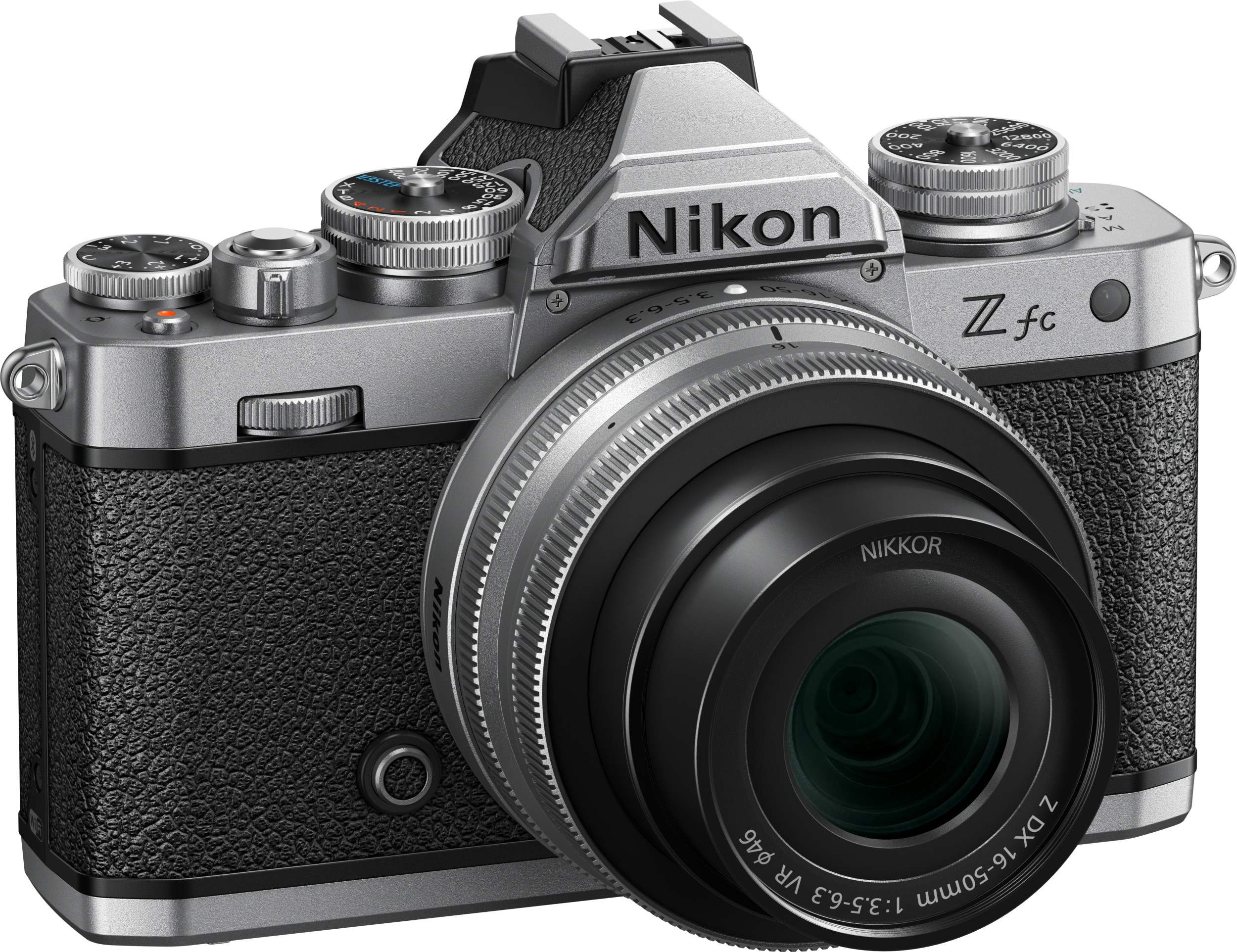 Silberne Nikon Z fc Kamera mit Objektiv. Schwarzer strukturierter Griff und silberne Knöpfe. Nikon Z fc sichtbar.