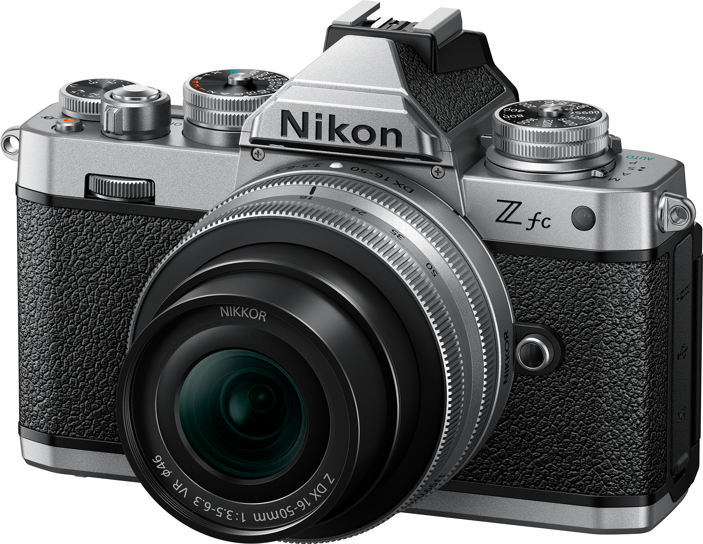 Appareil photo argenté Nikon Z fc avec objectif noir. Fond blanc uni.