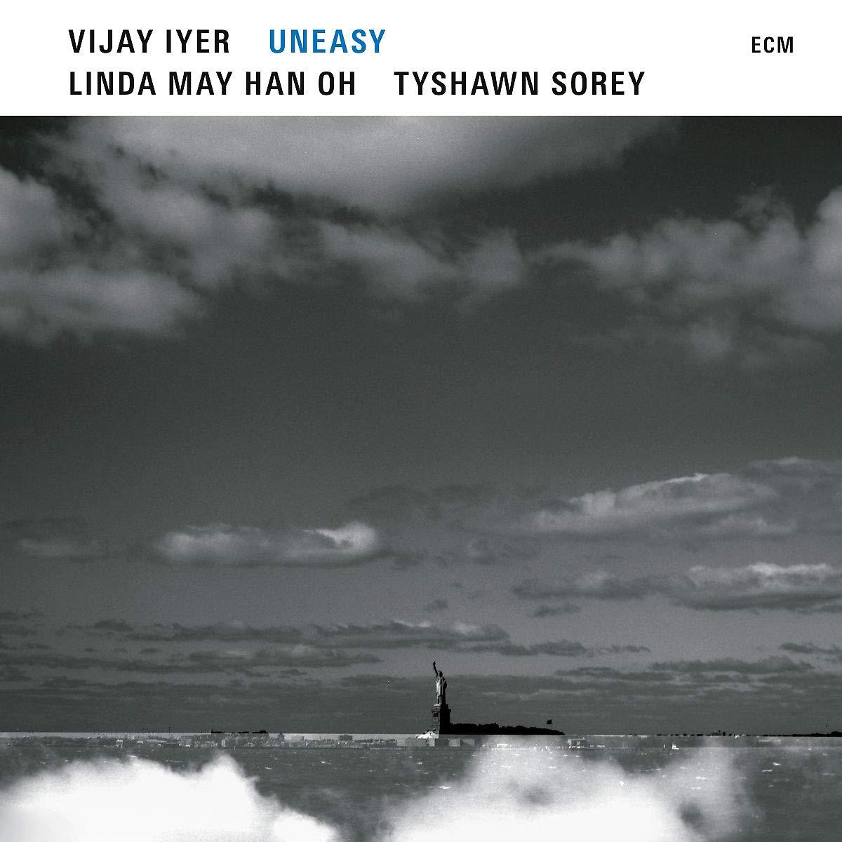 Album borító szöveggel: Vijay Iyer, Uneasy. Fekete-fehér kép a Szabadság-szoborról a távolban.