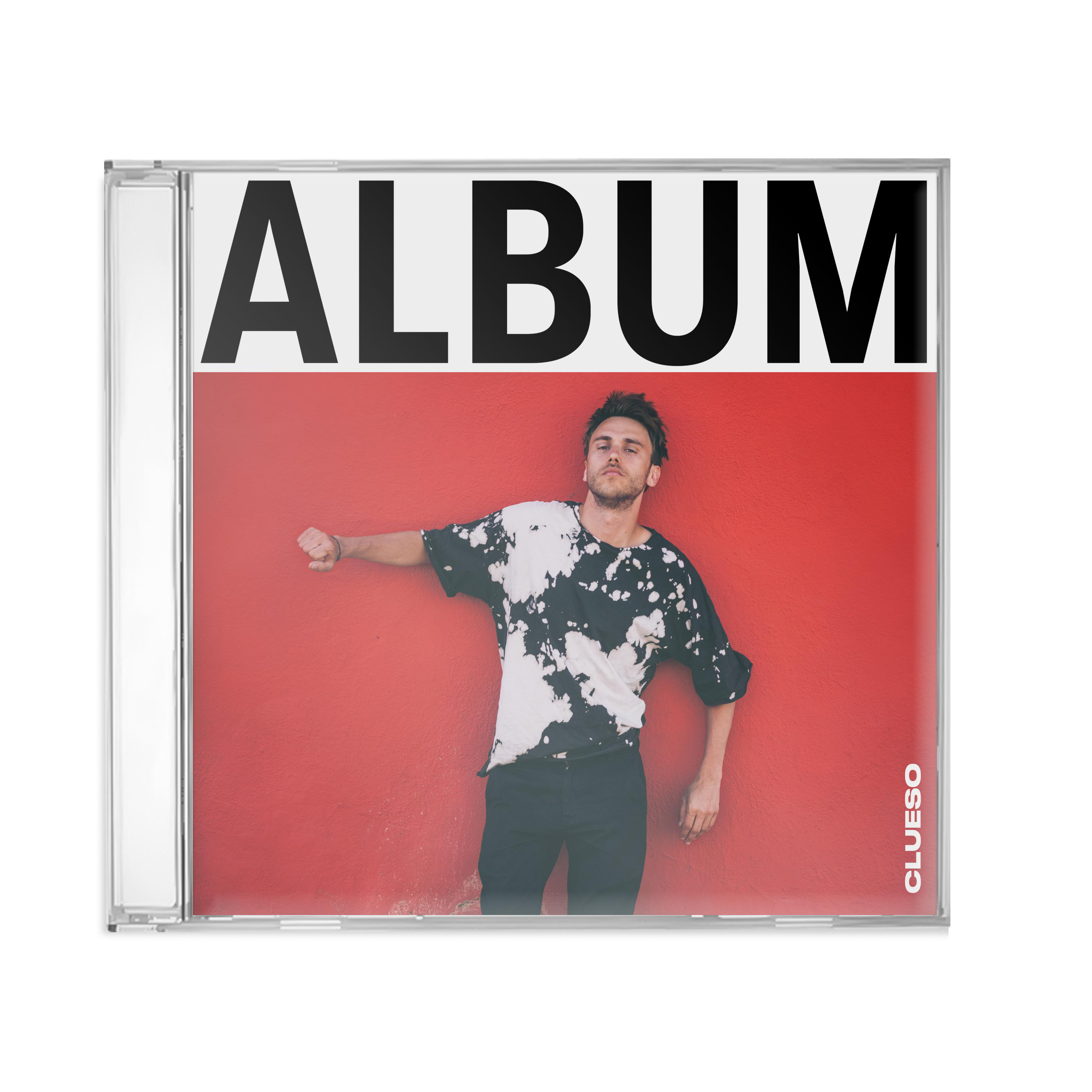 Album-CD-Hülle mit Mann in Batik-Shirt vor roter Wand.