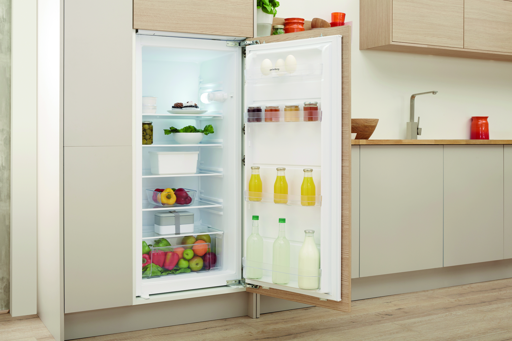 Ein offener Kühlschrank mit sichtbaren Lebensmitteln auf Regalen und Türfächern.