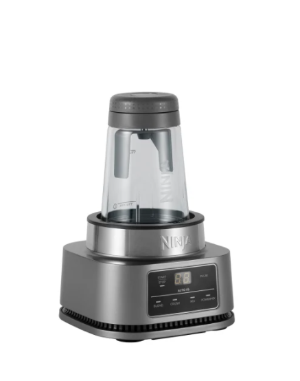 Ein Ninja-Mixer, silberfarbener Sockel mit einem transparenten Behälter. Der Behälter hat einen grauen Deckel. Das Bedienfeld zeigt Einstellungen.