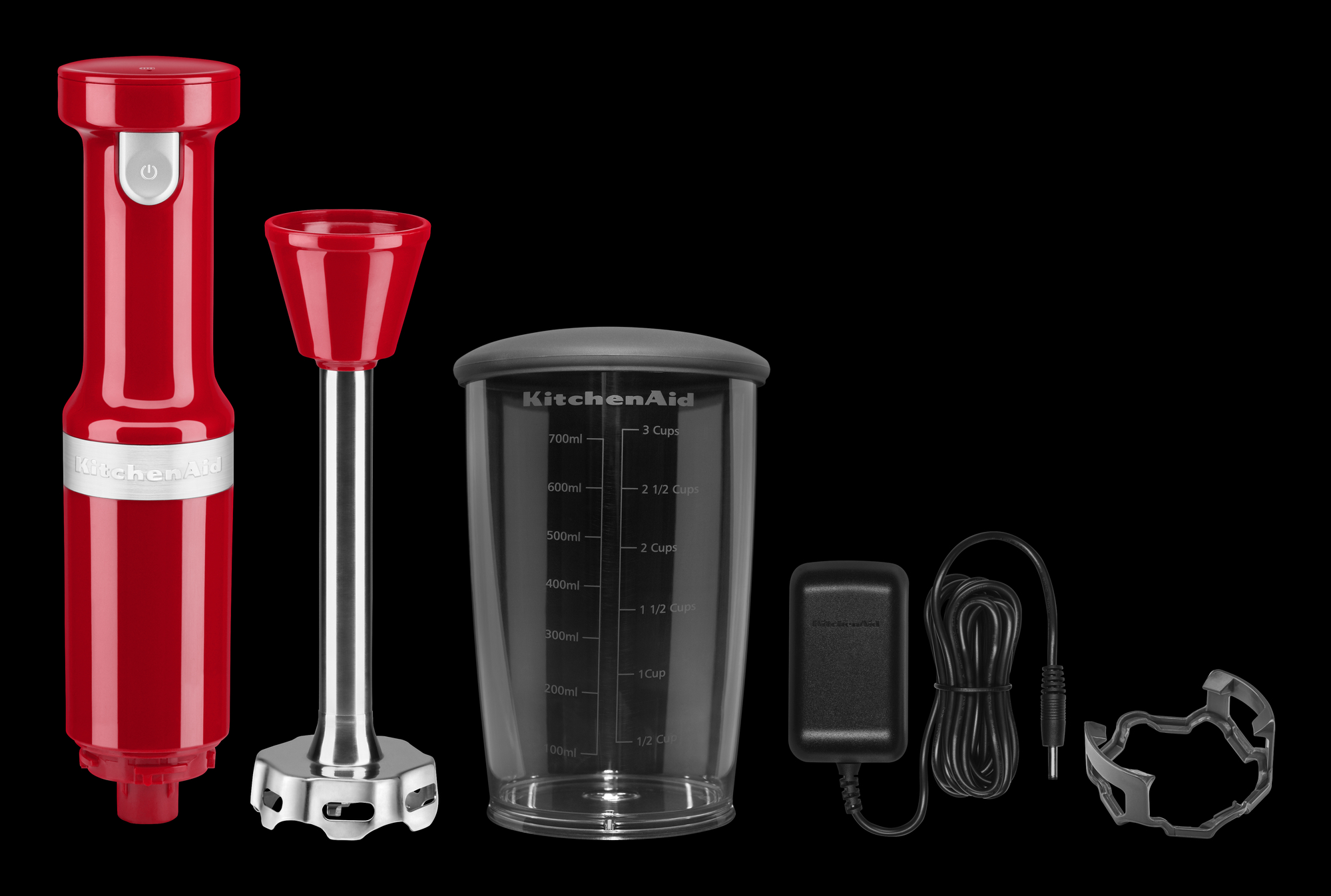 Ein roter KitchenAid-Handmixer mit Zubehör, auf schwarzem Hintergrund.