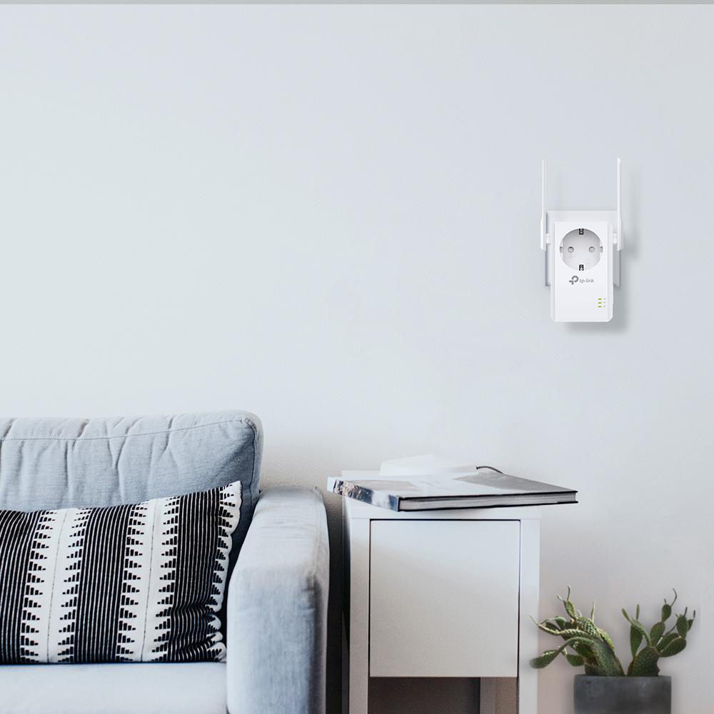 Weiße Wand mit einem eingesteckten WLAN-Repeater. Ein Sofa und ein Beistelltisch mit Pflanze sind vorhanden.