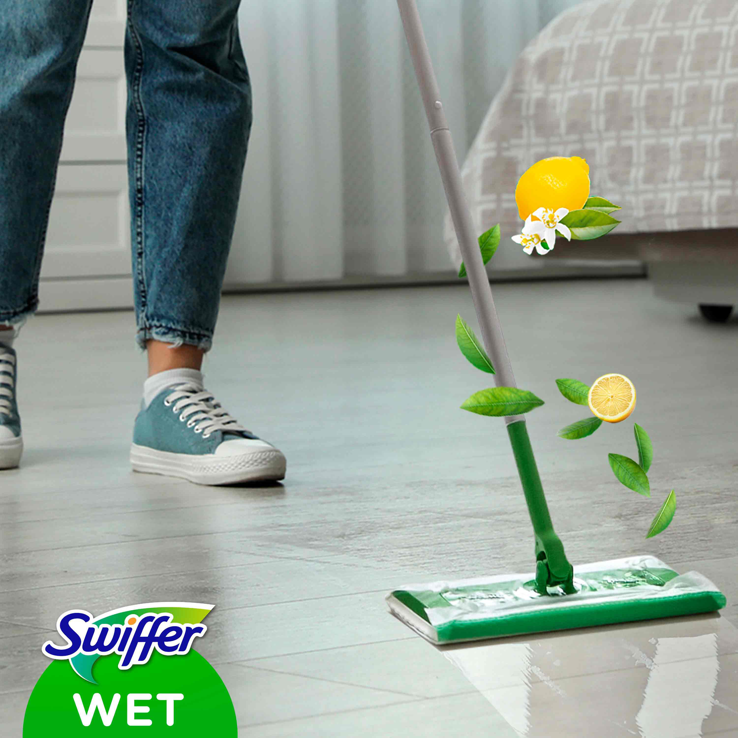 Swiffer Wet-Mopp, der den Boden reinigt, mit Zitrone und Blättern, die schweben. Person in Jeans.
