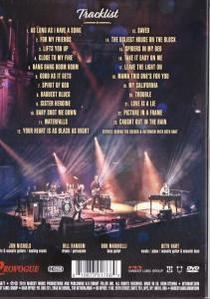 DVD-hoes toont een live concertpodium met een band, met vermelding van nummers en bandnamen.