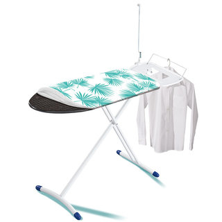 Une table à repasser avec des pieds blancs, un motif de palmiers turquoise et une chemise blanche sur un cintre.