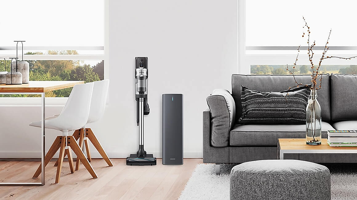 Wohnzimmer mit Staubsauger, Ladestation und Sofa, das ein modernes, sauberes Innendesign zeigt.