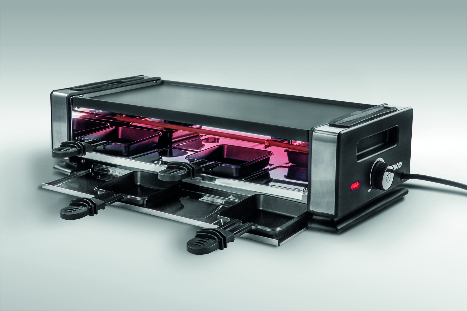 Raclette-Grill mit vier Pfannen, einer Kochplatte und Heizelementen.