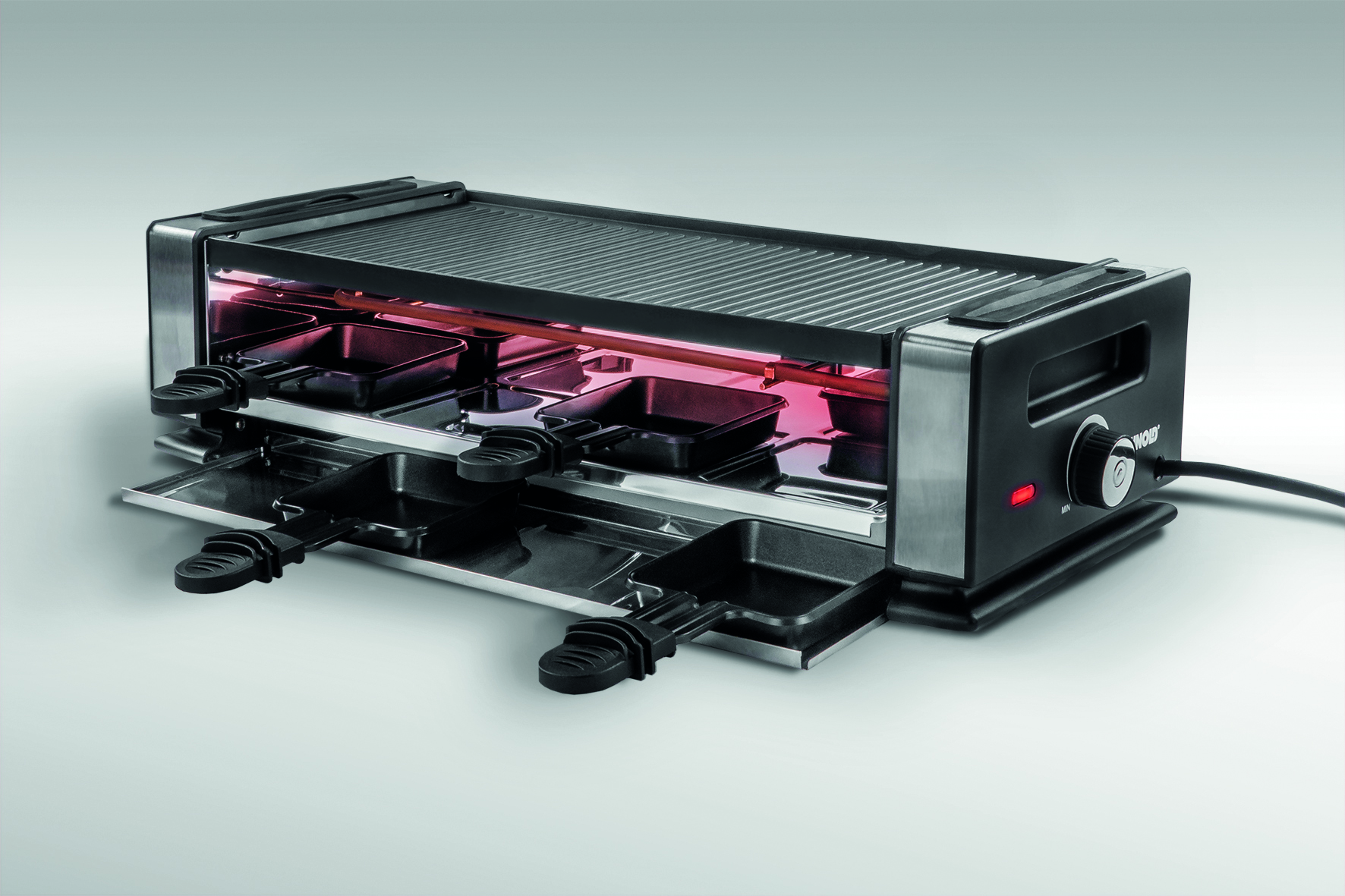 Raclette-Grill mit Pfannen und Heizelementen, weißer Hintergrund.