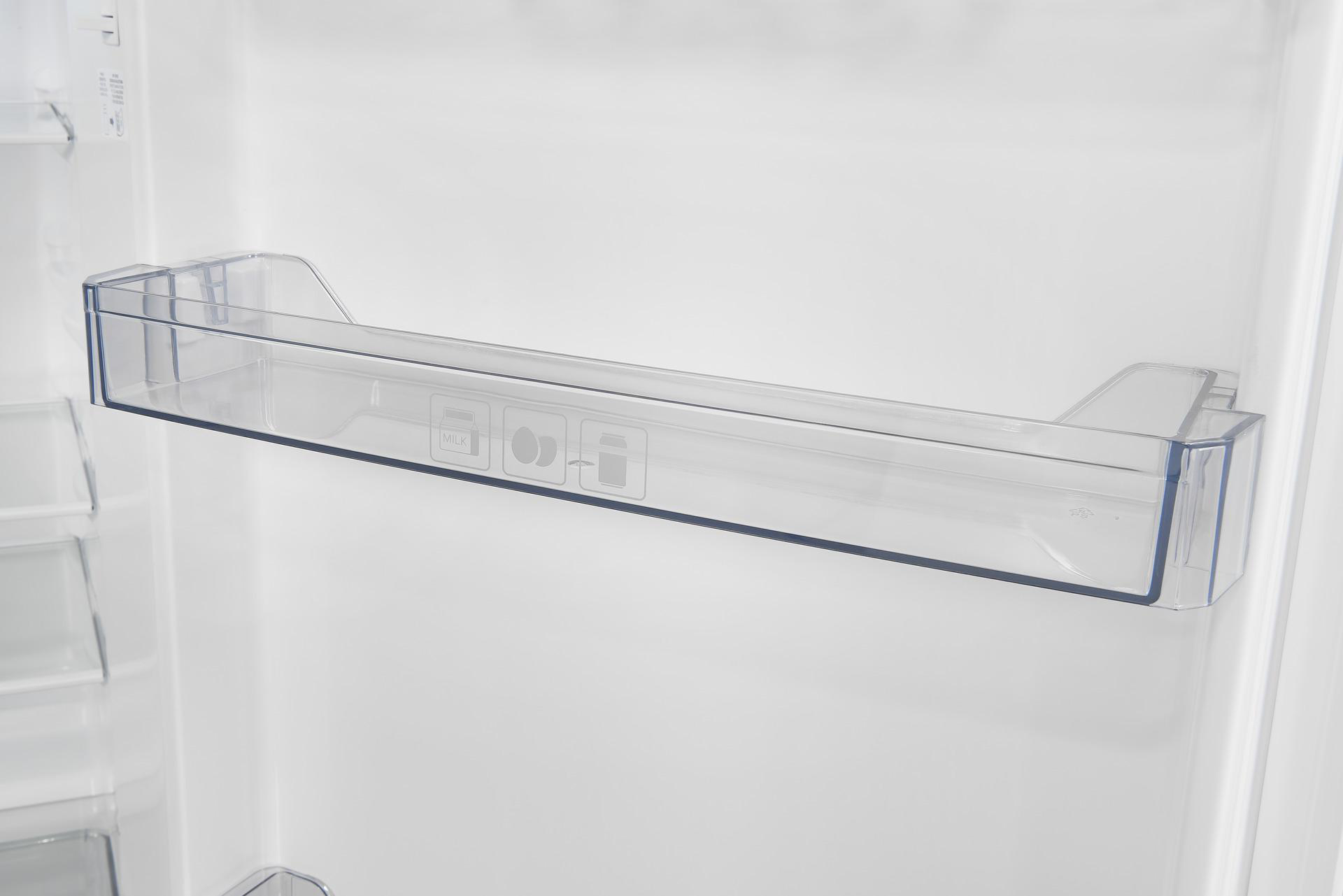 Innenseite eines Kühlschranks. Ein transparentes Regal ist an der Wand befestigt.