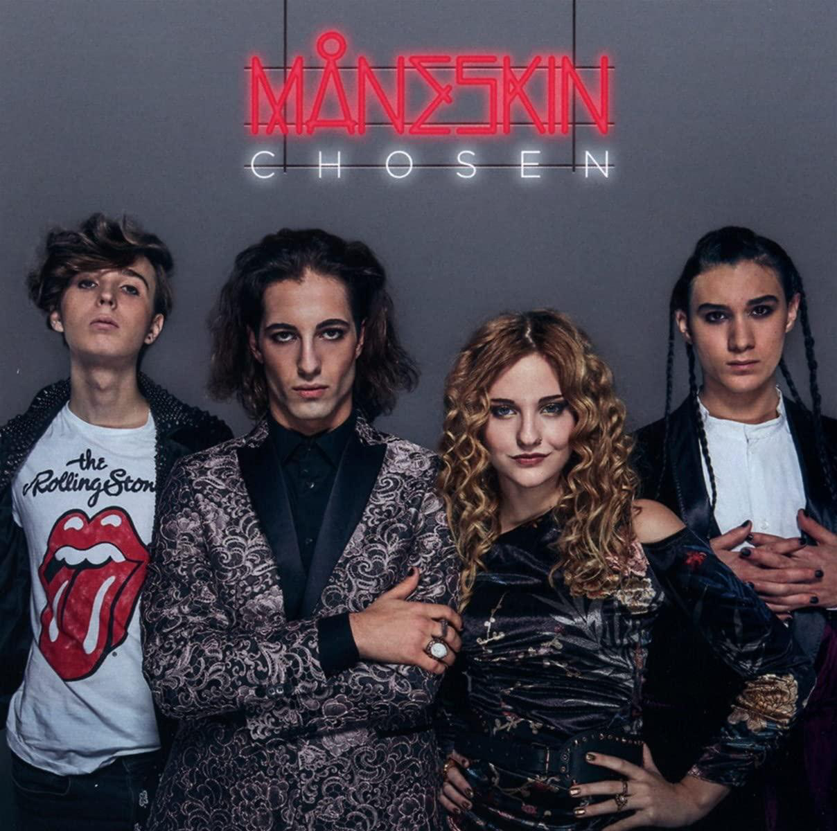 Maneskin-Bandmitglieder posieren vor einem Neonschild mit der Aufschrift 'MANESKIN CHOSEN'.
