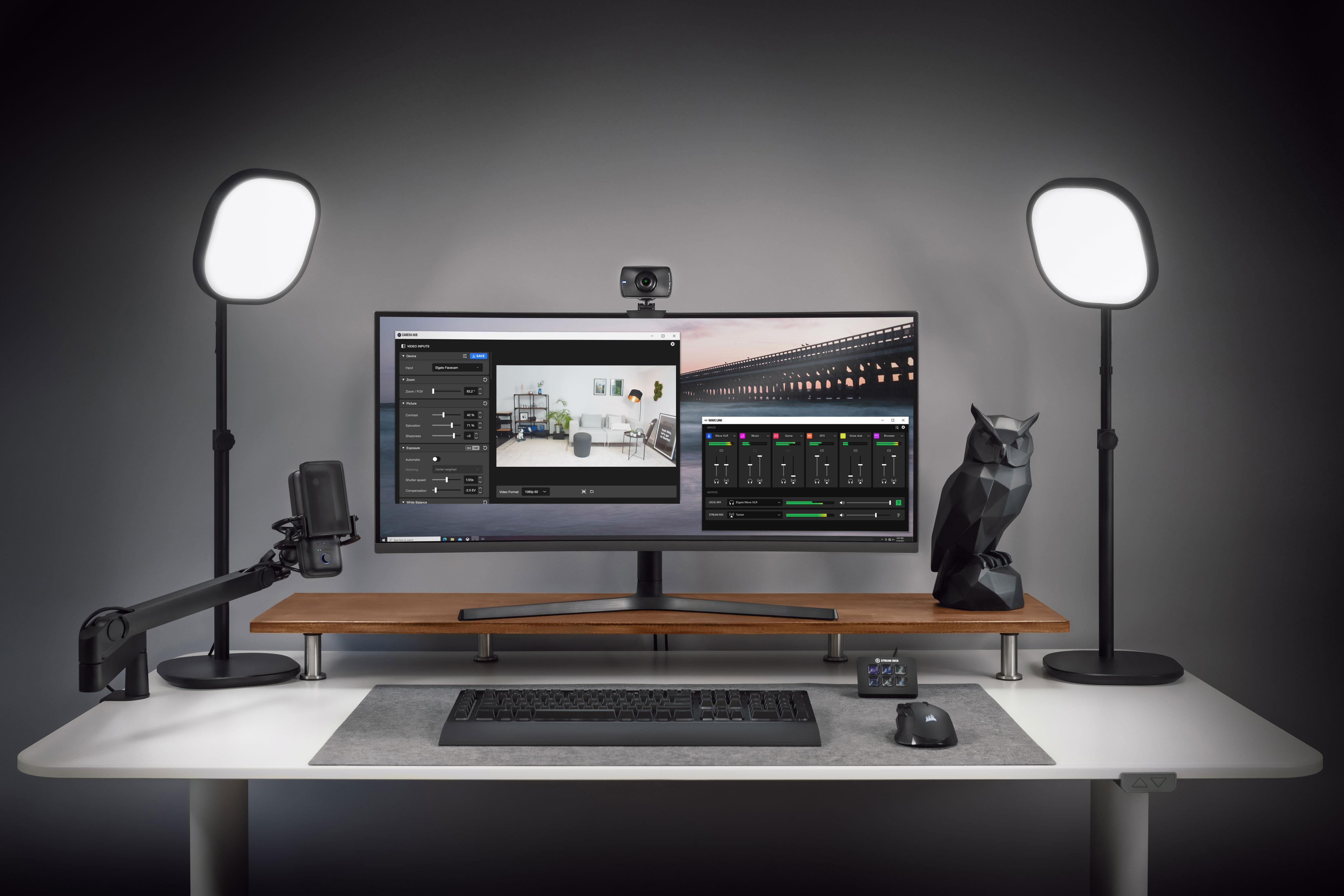 Ein Schreibtisch-Setup mit Monitor, zwei Lichtern, einem Mikrofon und Streaming-Zubehör.