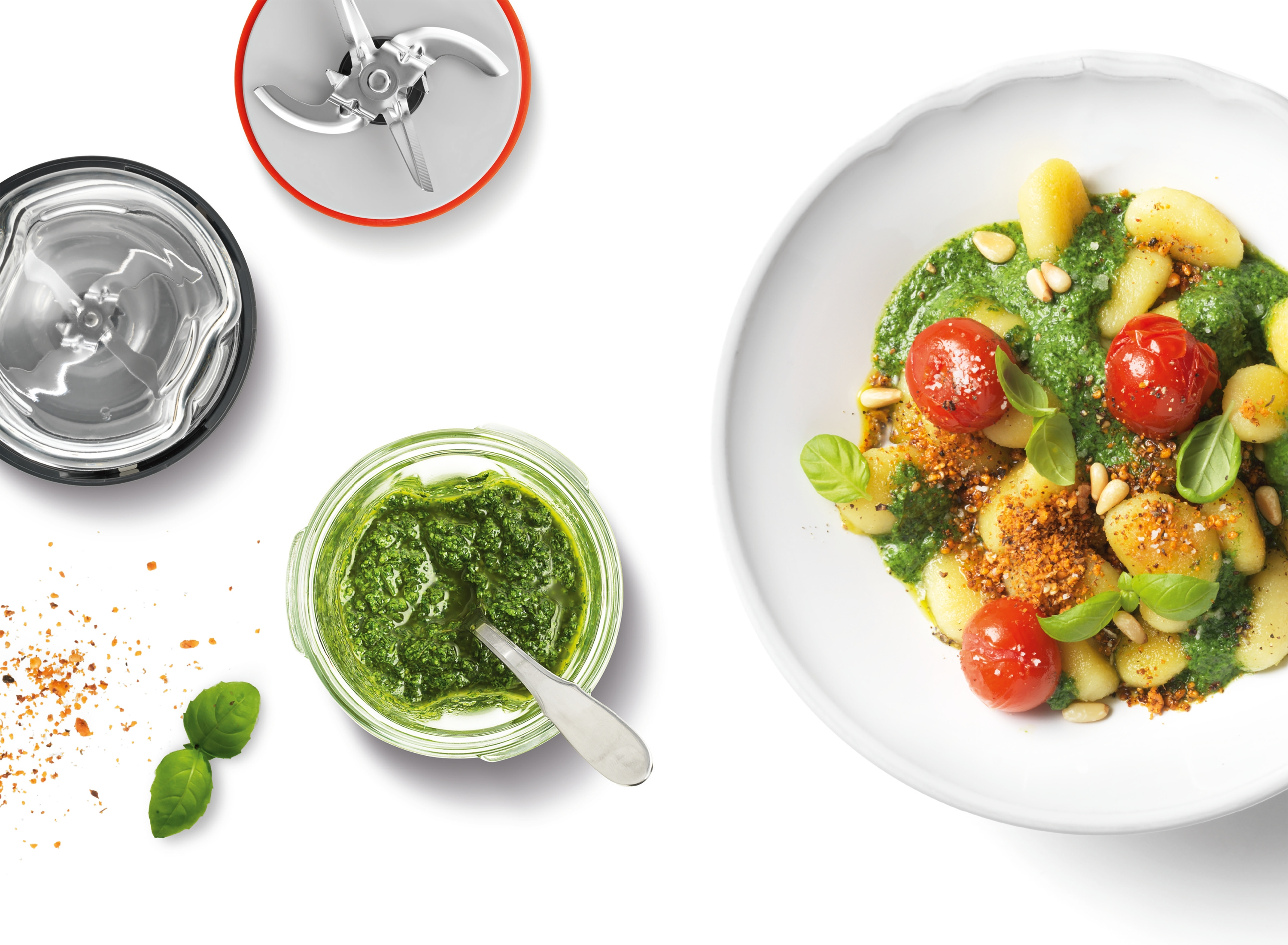 Gnocchi mit Pesto, Kirschtomaten und Pinienkernen in einer Schüssel, mit Pesto und Zubehör.