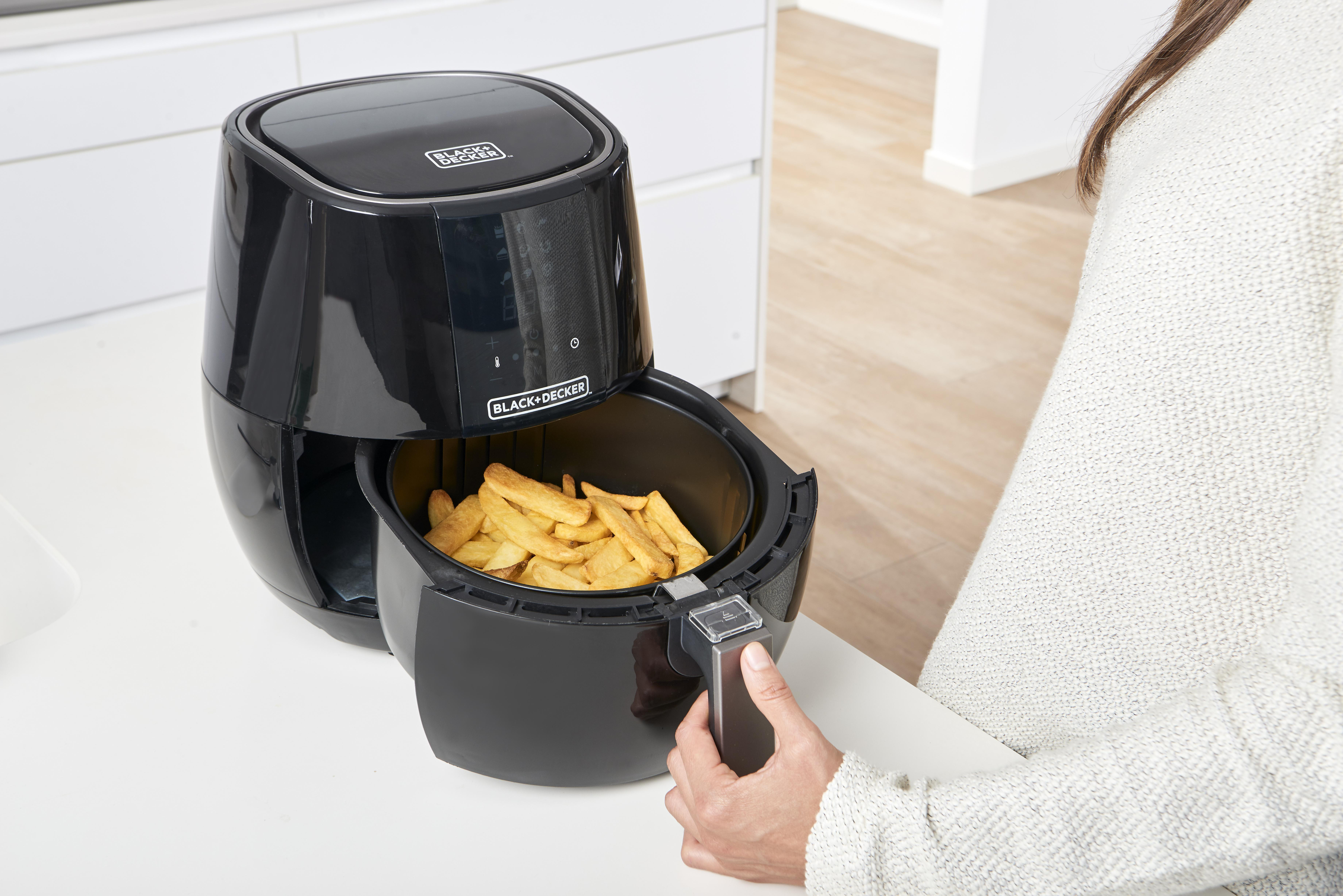 Schwarze Heißluftfritteuse mit Pommes frites.