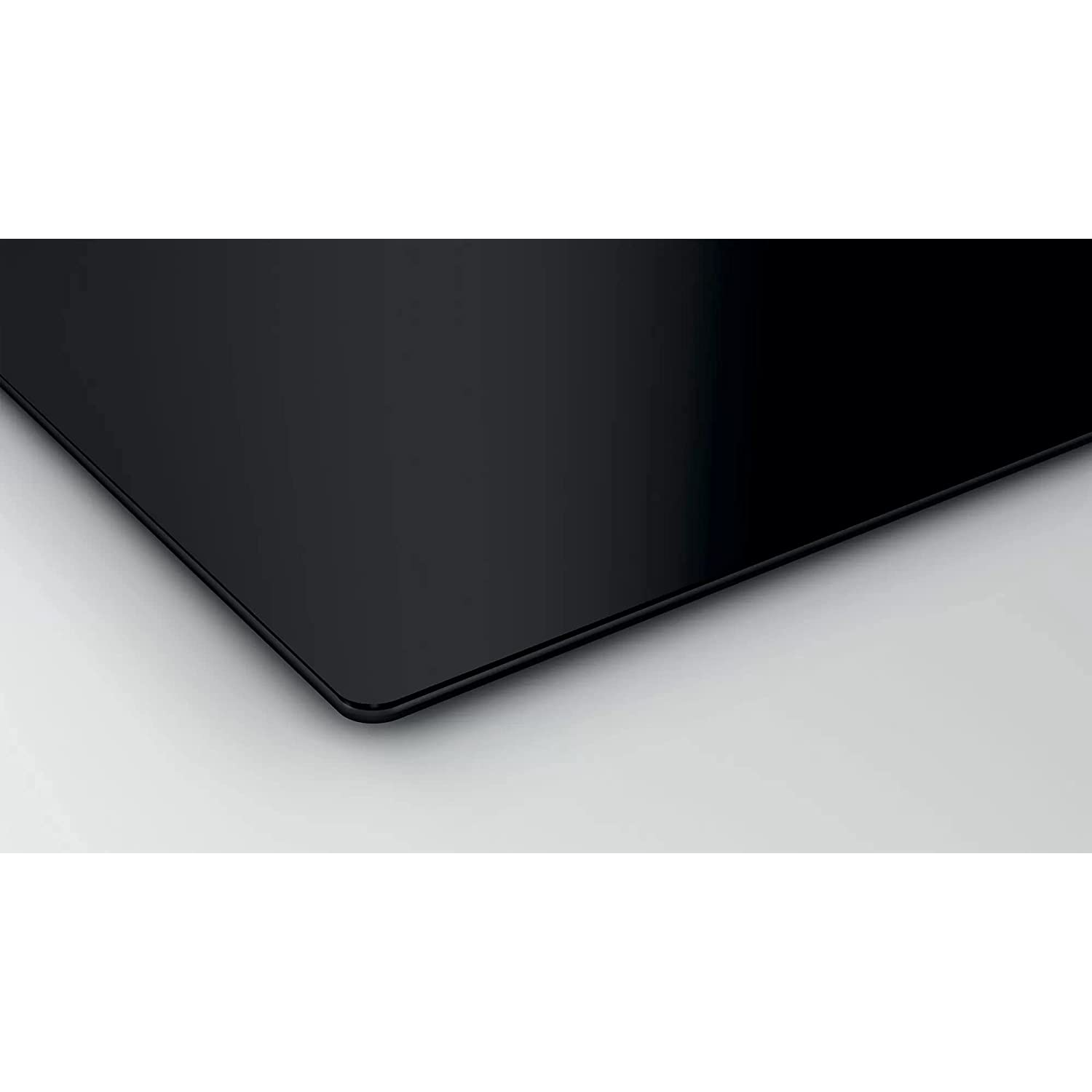 Primer plano de una superficie de vitrocerámica negra, brillante y rectangular.