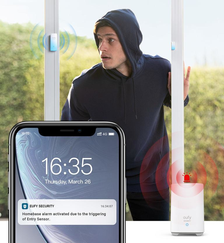 A man looking at his phone with an alarm notification, and a security device nearby.