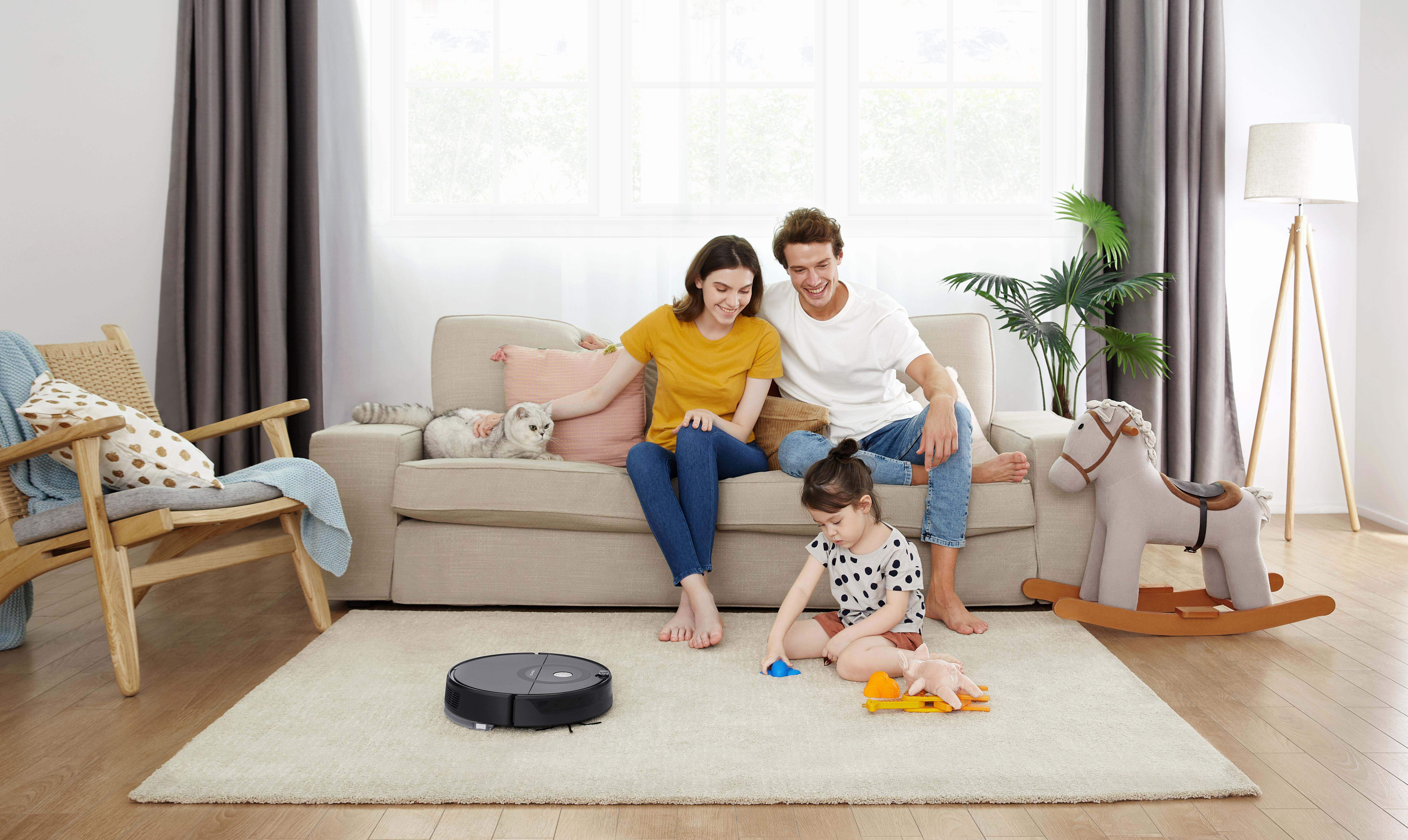 Familie im Wohnzimmer mit Roboter-Staubsauger.