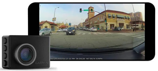 Caméra embarquée Garmin noire à côté d'un écran de smartphone montrant une vue de la rue.