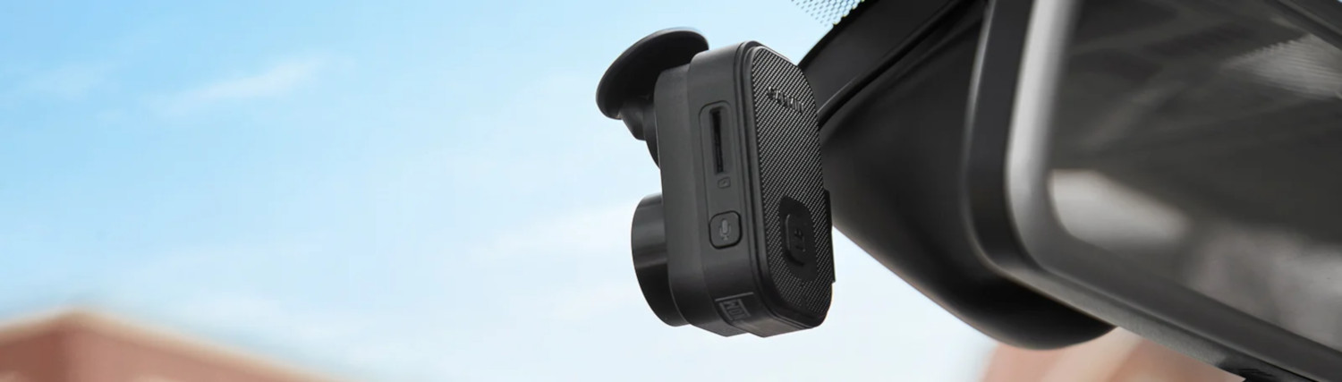 Close-up van een dashcam bevestigd aan een voorruit.
