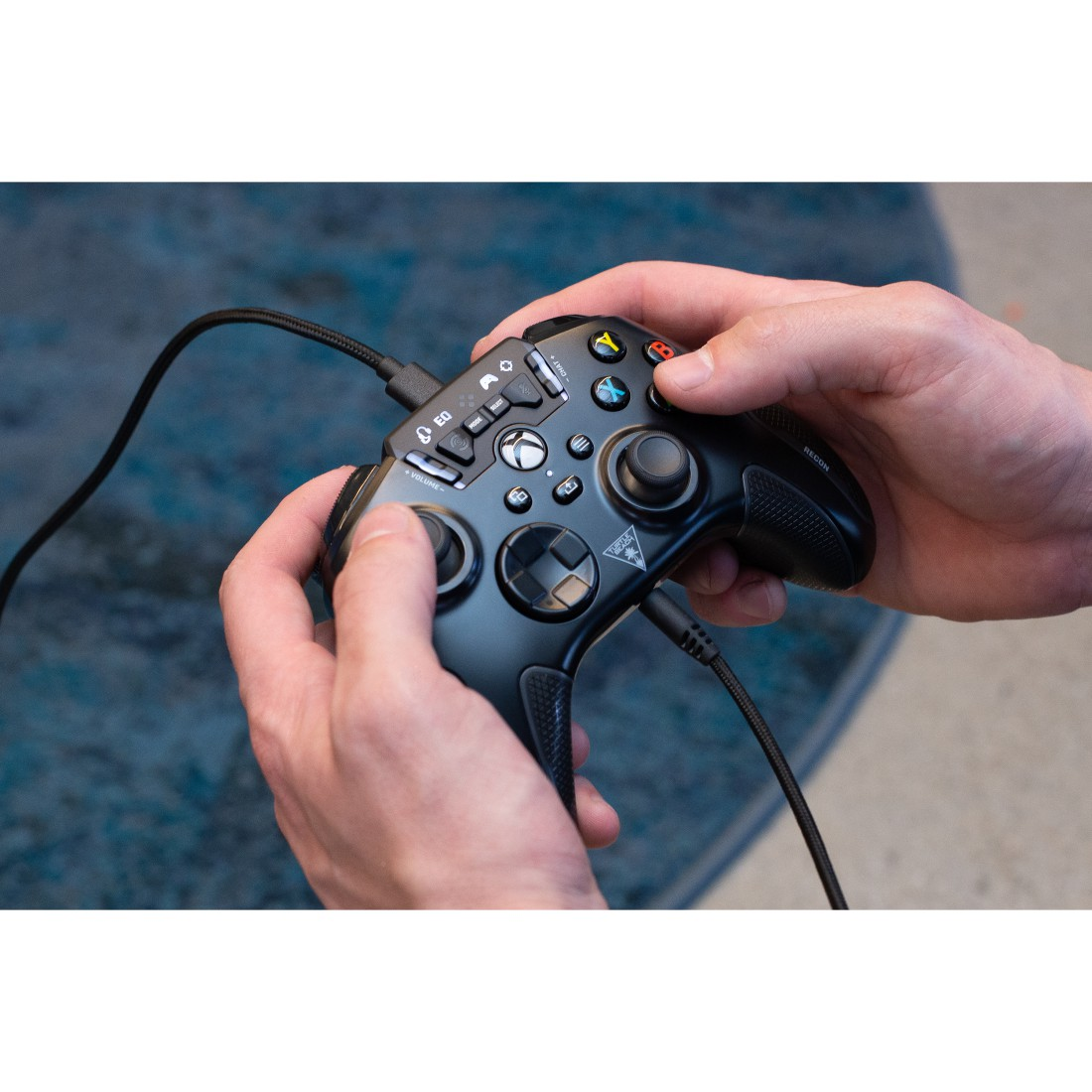 Hände halten einen schwarzen Xbox-Controller. Der Controller hat Knöpfe und Joysticks.