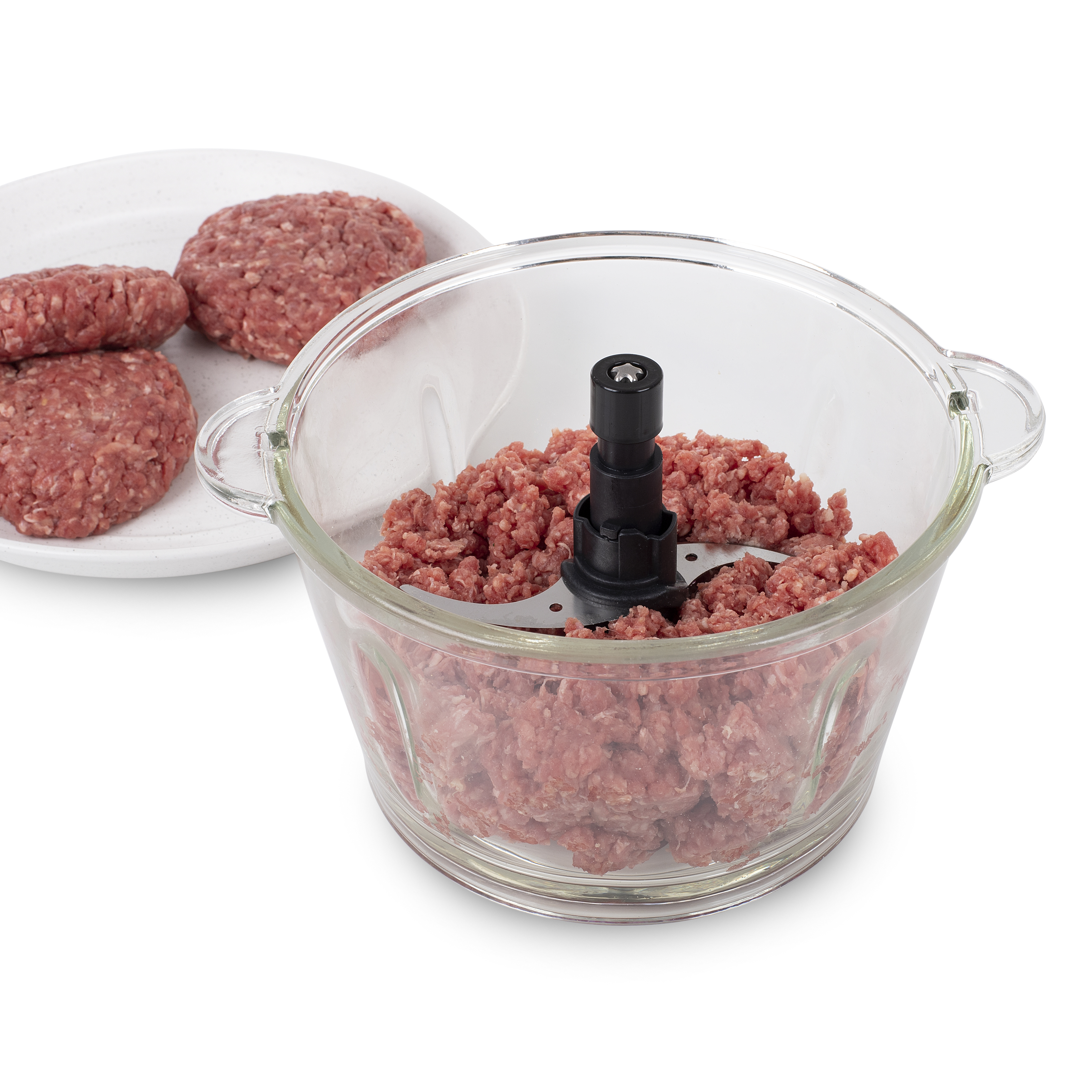 Gehakt in een glazen kom, naast een bord met rauwe hamburgerpasteitjes.