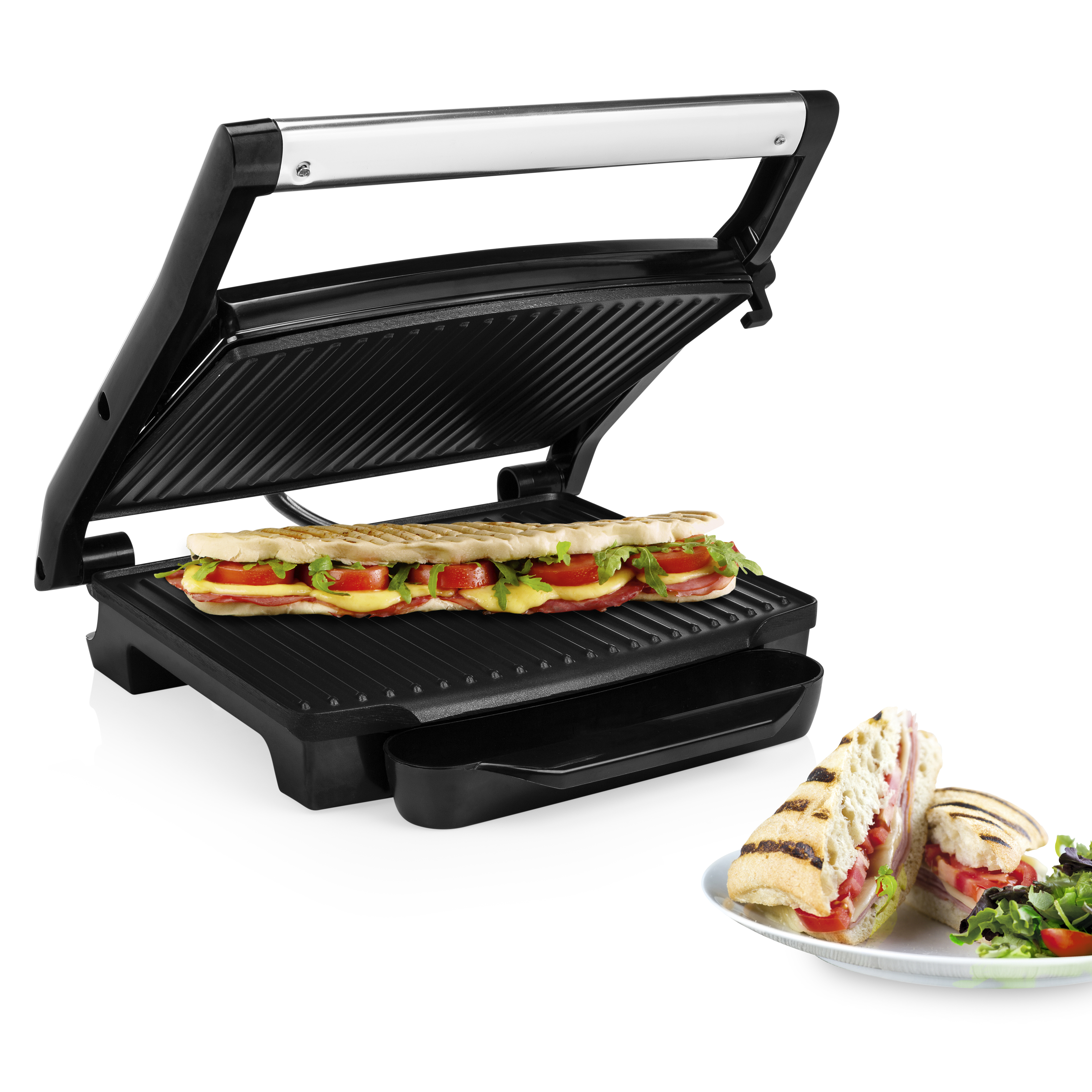 A panini press with a panini on it and a plate with salad.