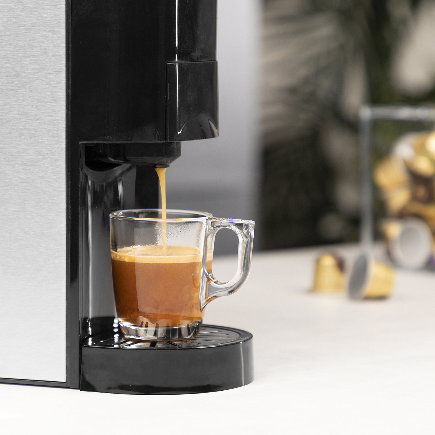 Een espressomachine die koffie in een glazen kopje doseert.