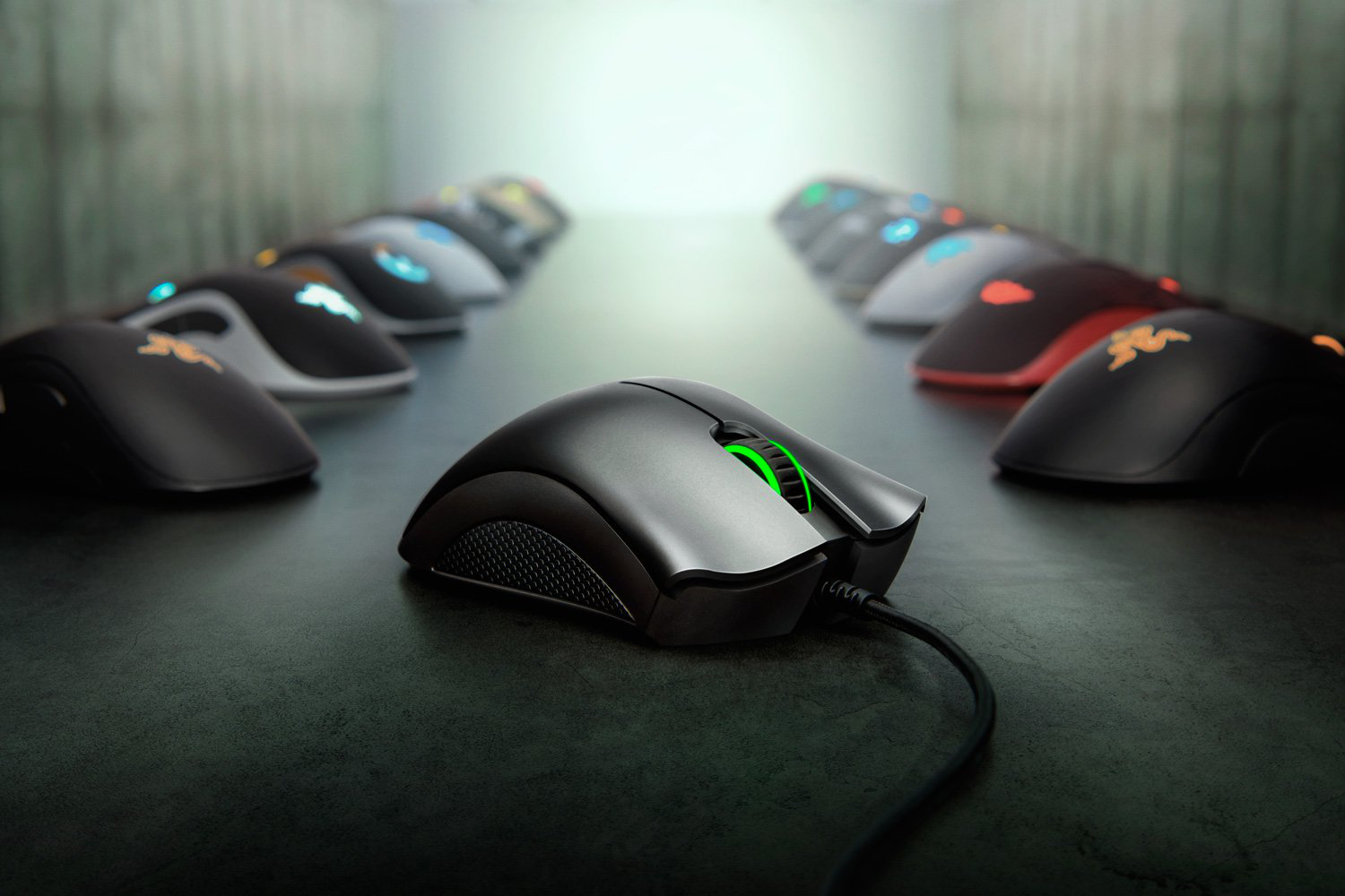 Eine schwarze Razer-Maus mit grünem Licht, umgeben von anderen Mäusen auf dunkler Oberfläche.