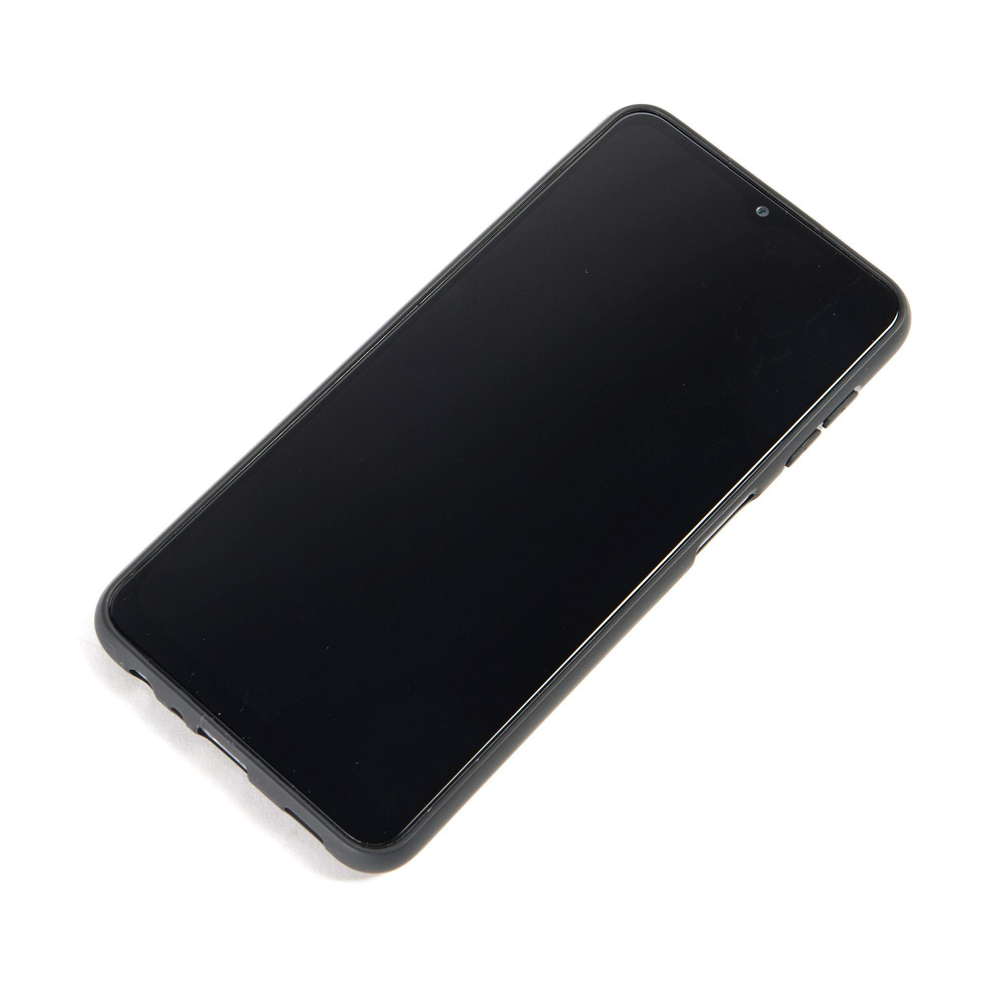Ein schwarzes Smartphone mit großem Bildschirm, das auf einer weißen Oberfläche liegt.