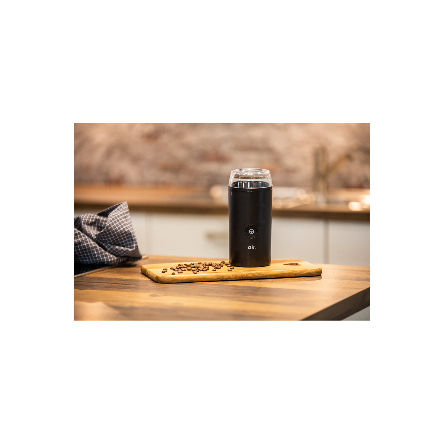 Molinillo de café negro en tabla de madera con granos. Fondo de cocina.