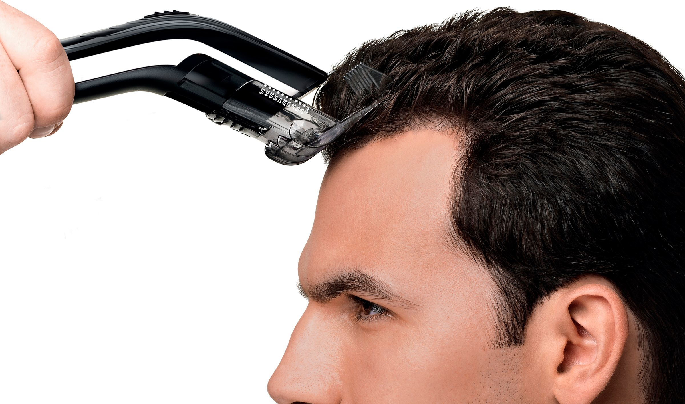 Les cheveux d'un homme sont coupés avec une tondeuse noire.