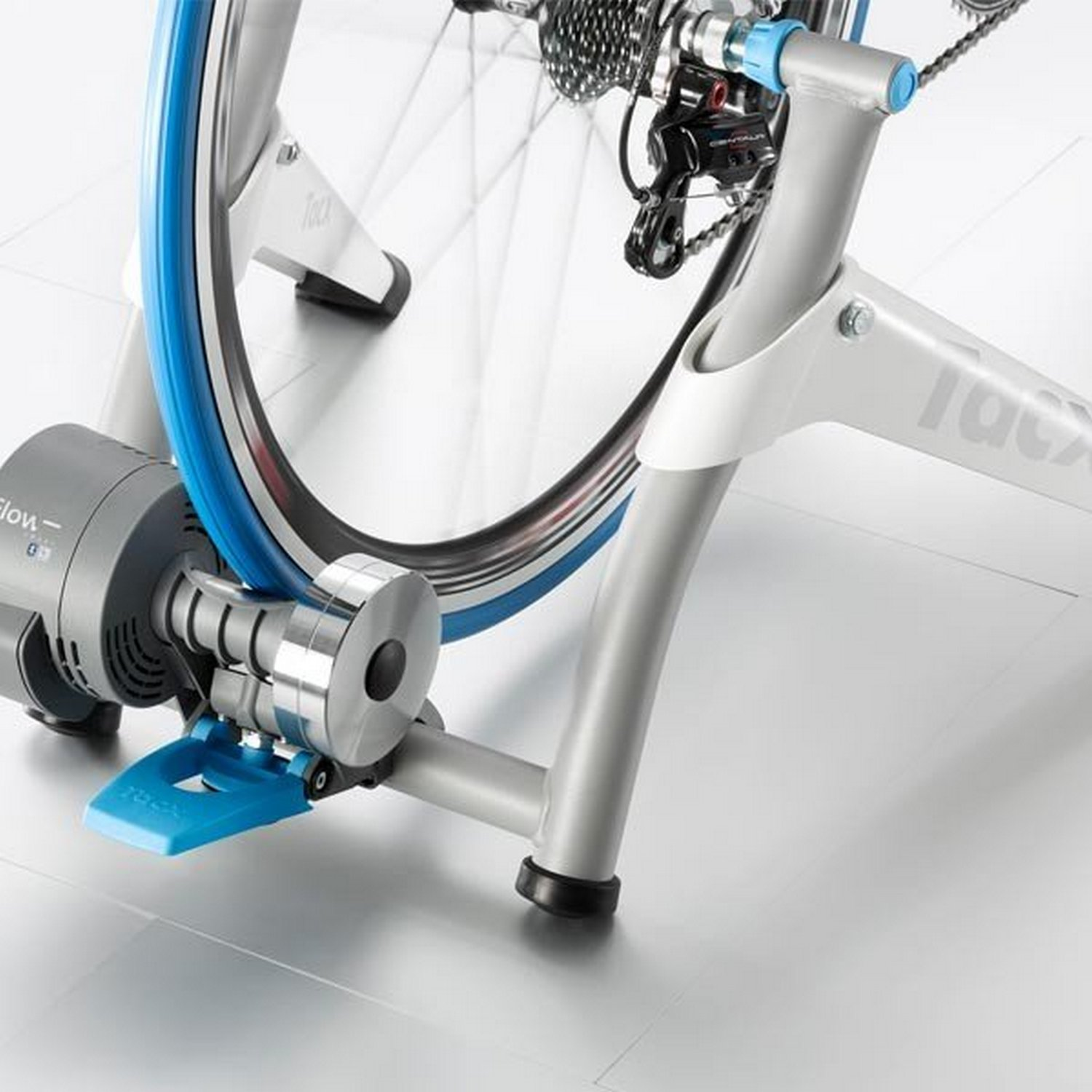 Una bicicleta está sobre un soporte gris. La rueda es azul y el soporte es gris y blanco.