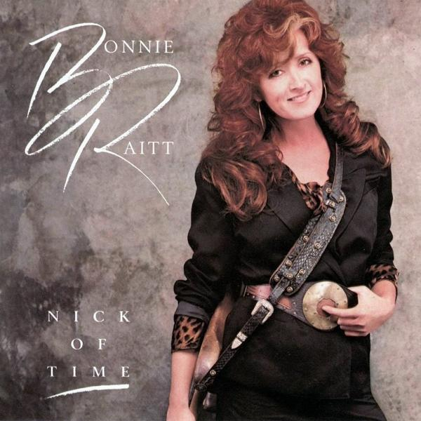 Bonnie Raitt gitárt tart egy szürke háttér előtt, Nick of Time felirattal.