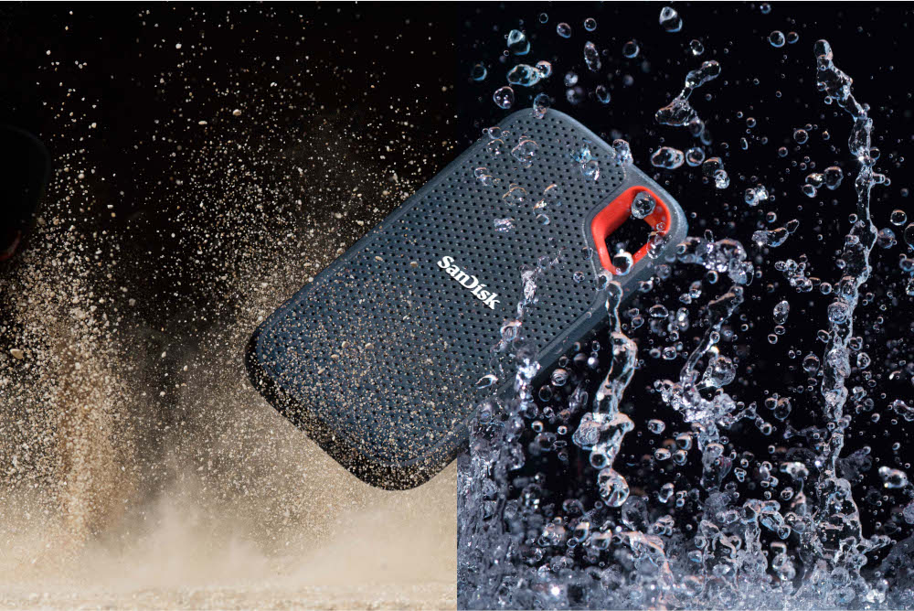 Disque dur externe Sandisk, avec accent rouge, éclaboussant dans l'eau, avec fond sombre.