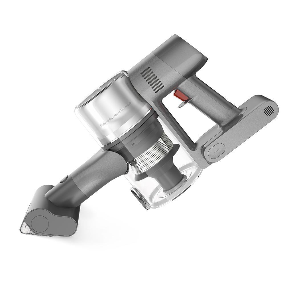 Person reinigt Fensterbank mit Handstaubsauger. Pflanze und Schmutz sichtbar.