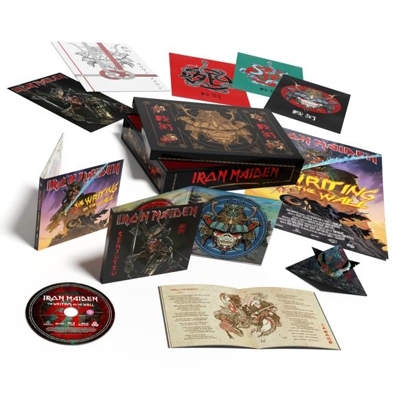 Iron Maiden album dobozkészlet különböző betétekkel, CD-vel és füzettel fehér háttéren, zenekari grafikákkal.