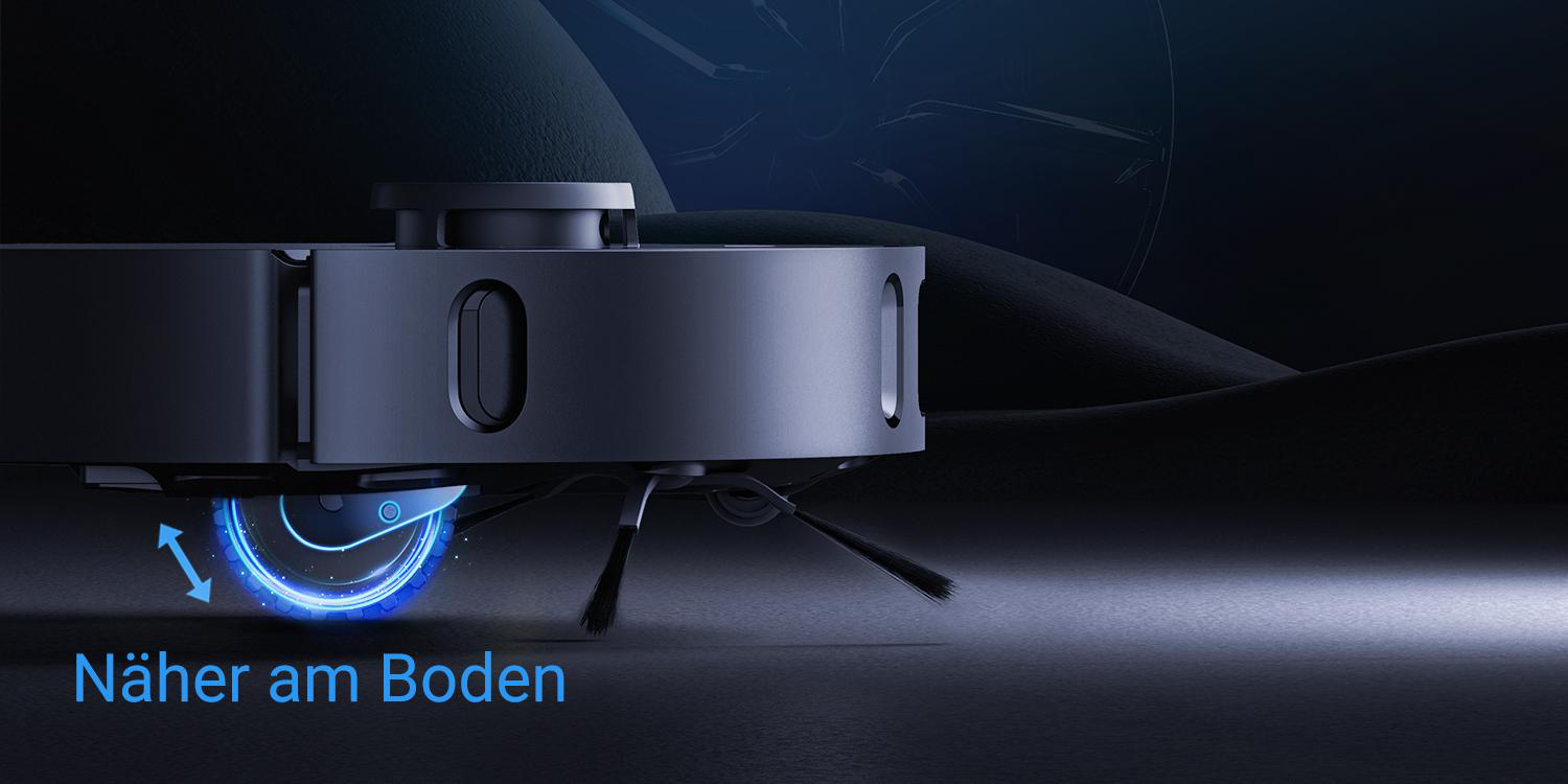 Roboter-Staubsauger auf dunkler Oberfläche, zeigt das Rad und den Text 'Näher am Boden'.