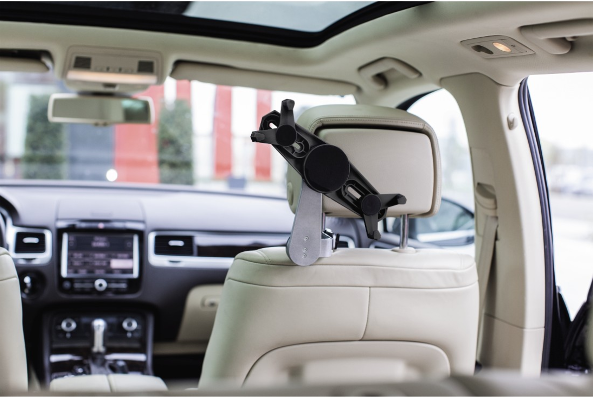 Appuie-tête de voiture avec support de téléphone fixé. Intérieur beige, toit ouvrant visible, intérieur de la voiture.