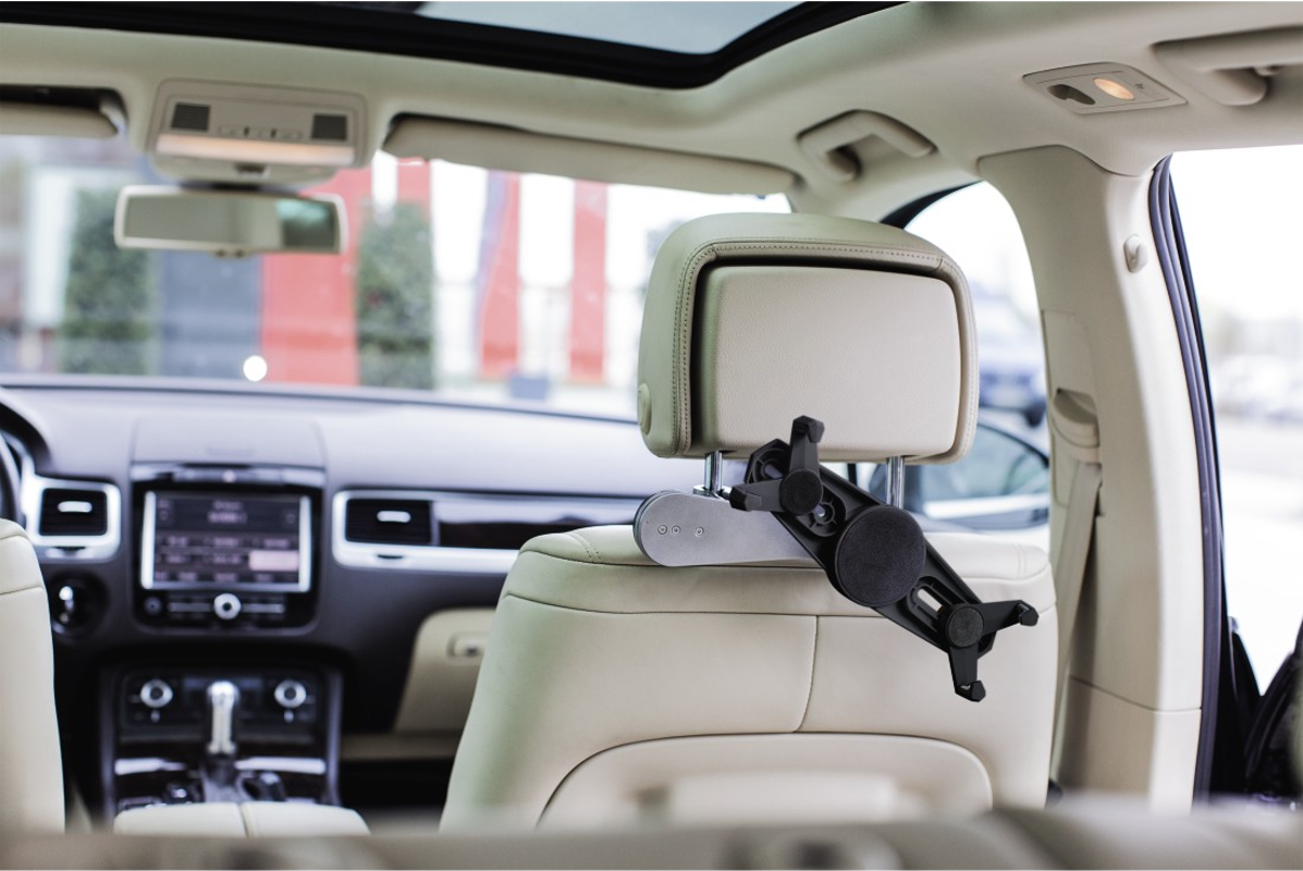 Support de tablette sur un appuie-tête de voiture, à l'intérieur de la voiture, avec tableau de bord visible.