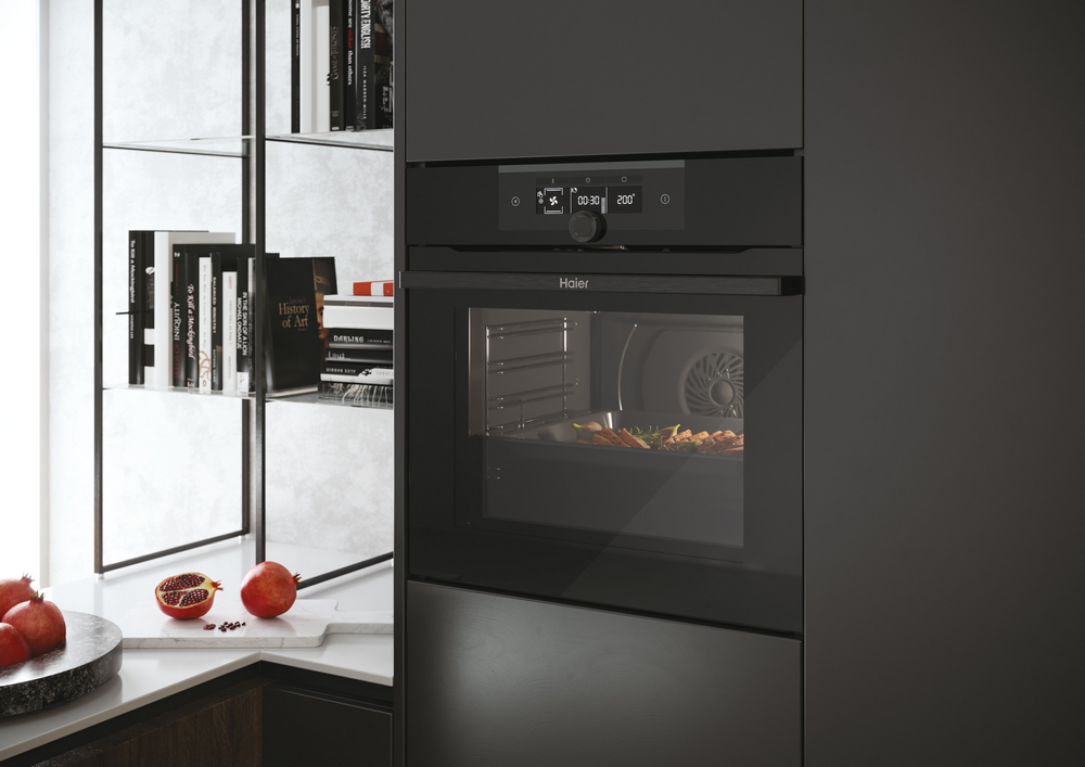 Horno negro sobre fondo oscuro, con comida dentro.