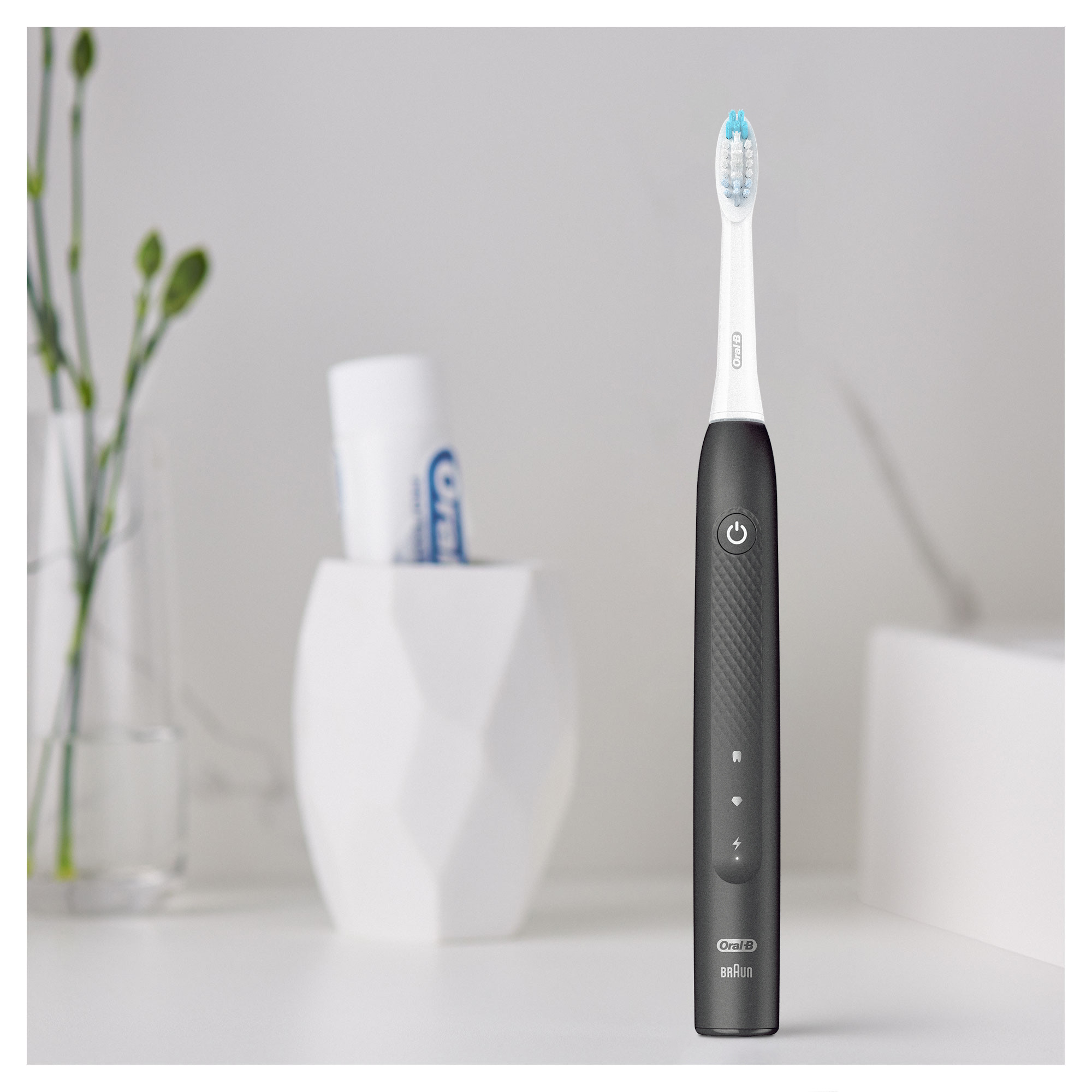 Schwarz-weiße elektrische Zahnbürste mit blauem Bürstenkopf auf weißer Oberfläche.