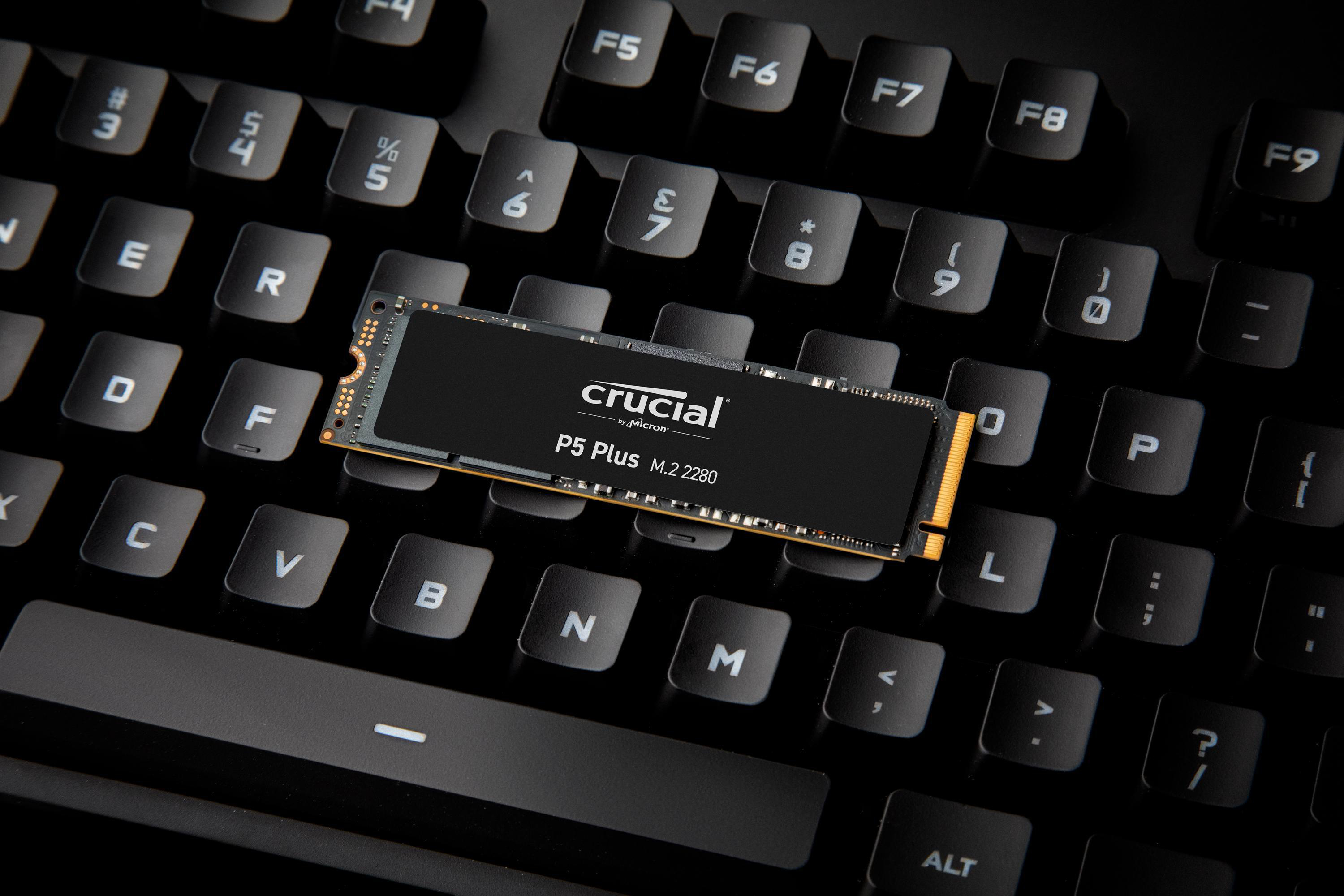 SSD Crucial P5 Plus M.2 2280 auf einer schwarzen Tastatur. Die Tastatur ist fokussiert, dunkle Umgebungsbeleuchtung.