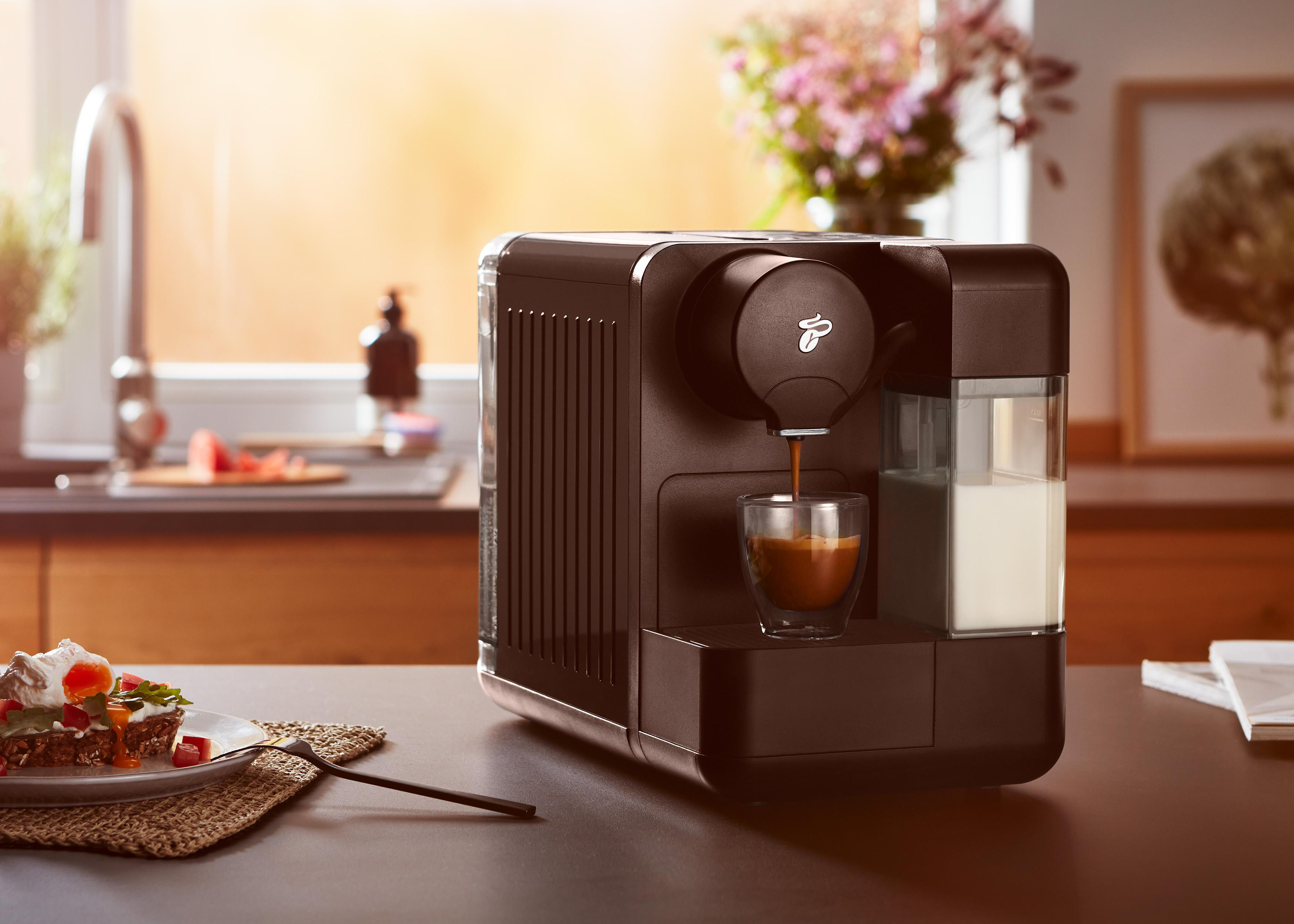 Eine dunkelbraune Kaffeemaschine mit einem Glas Kaffee.