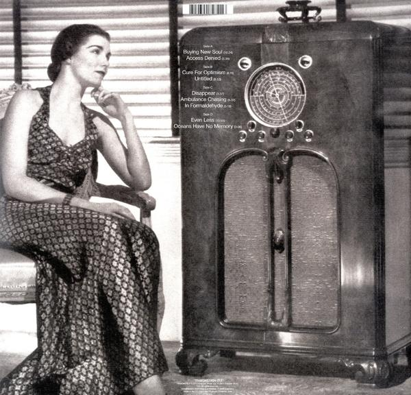 Eine Frau sitzt neben einem alten Radio. Sie trägt ein gemustertes Kleid. Das Radio hat ein Zifferblatt und einen Lautsprecher.