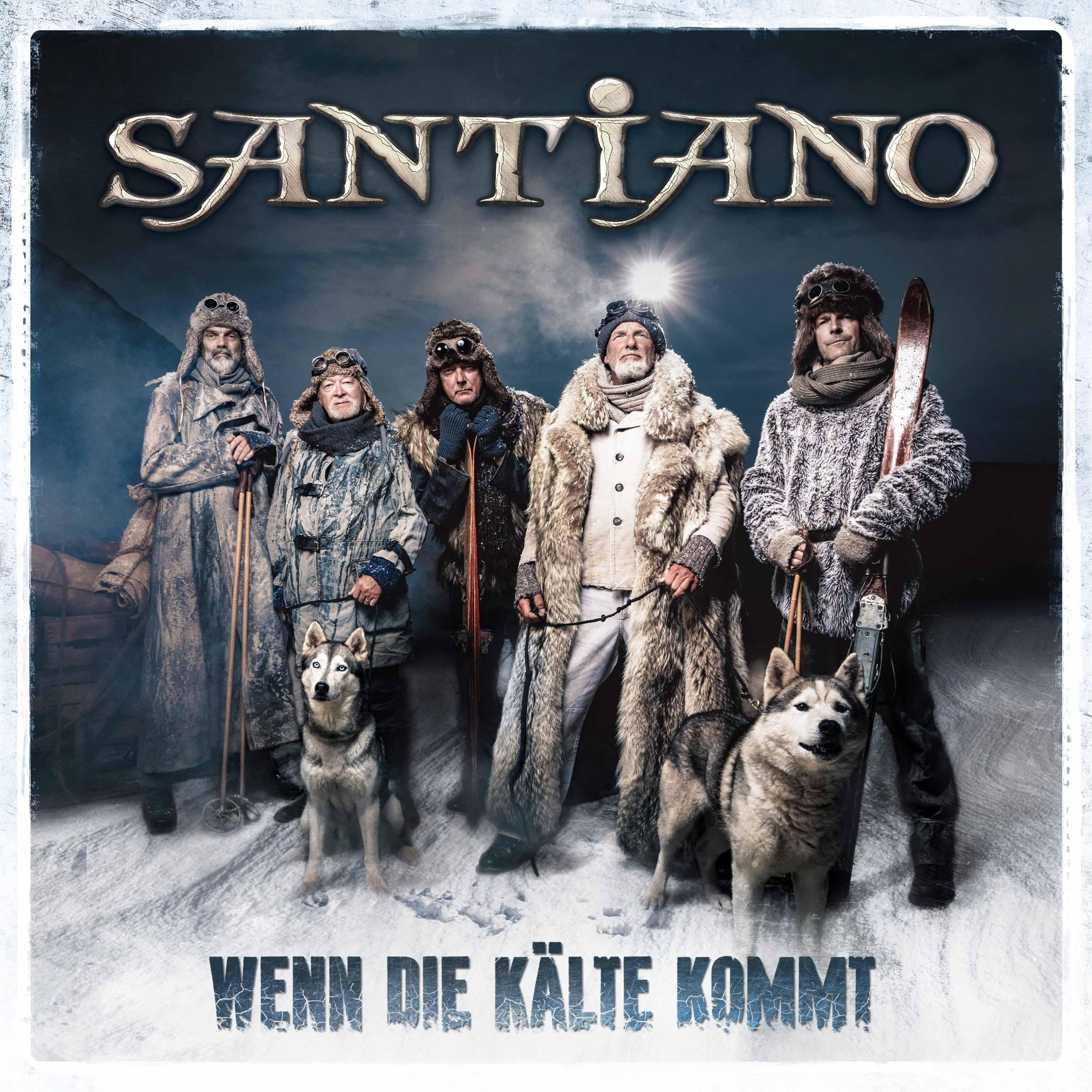 Männer in Winterkleidung posieren mit Huskys, und der Bandname.