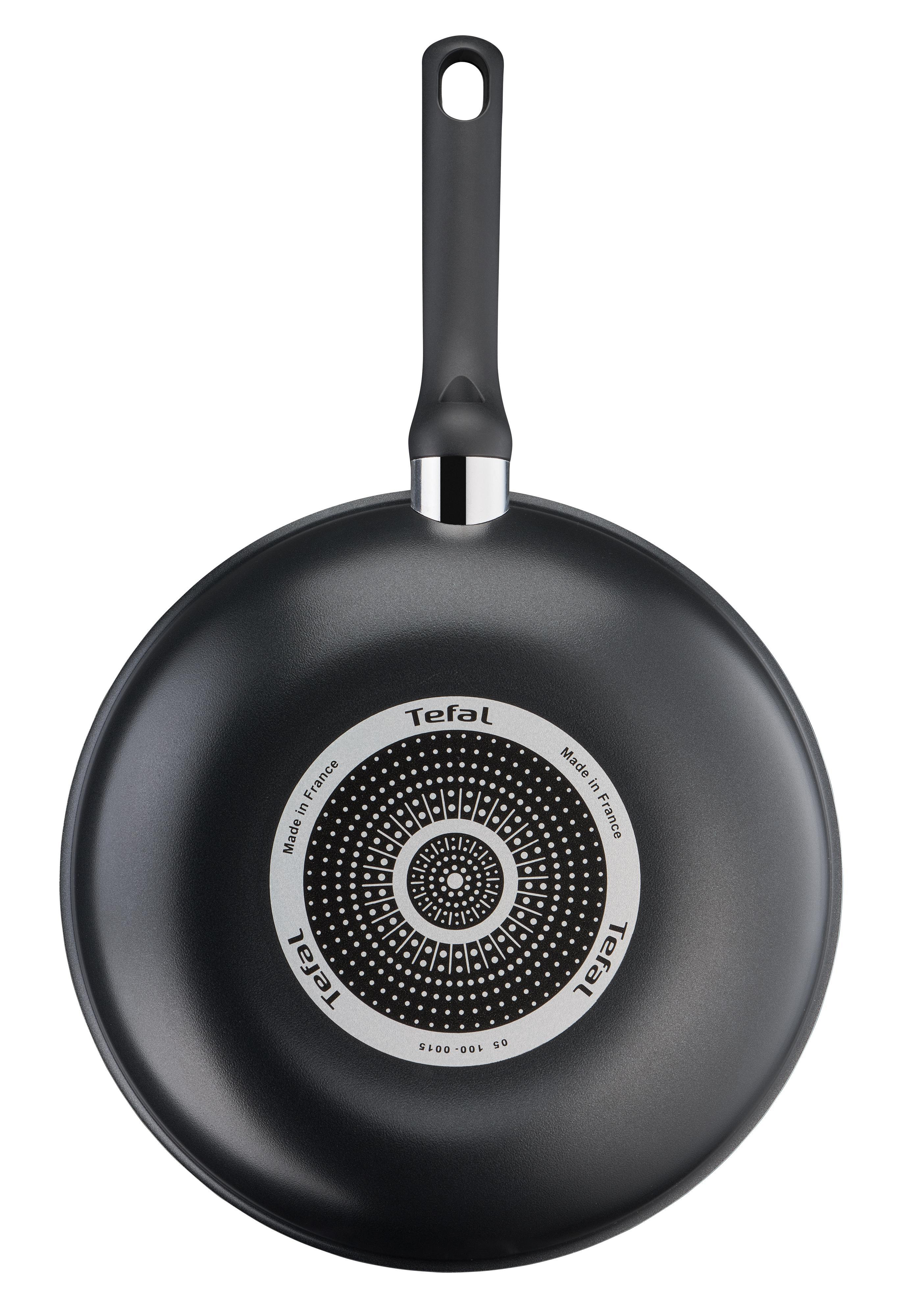 Schwarze Tefal Wok-Pfanne, Unteransicht. Der Boden ist schwarz mit kreisförmigem Design.