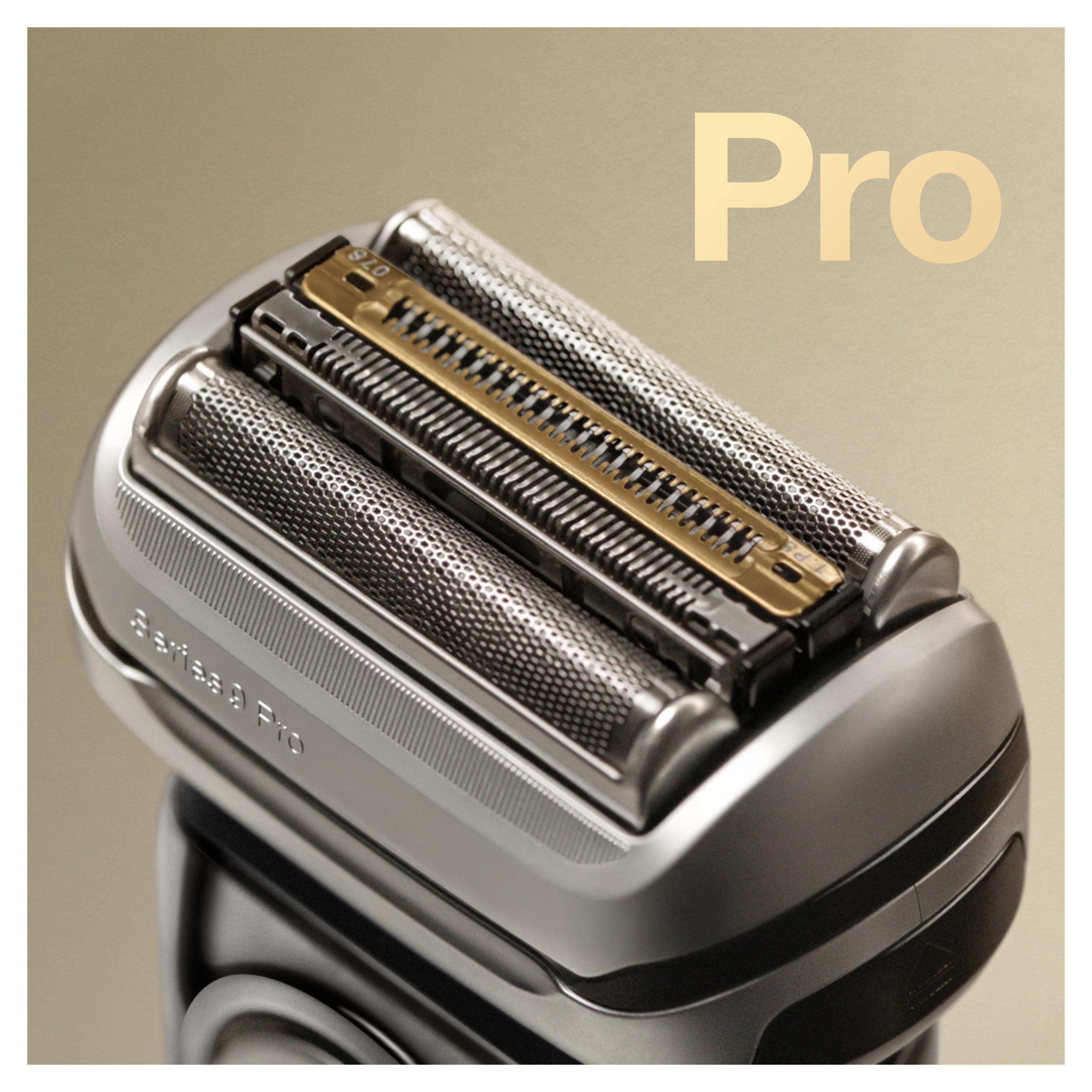 Nahaufnahme eines silbernen elektrischen Rasiererkopfes mit drei Klingen und dem Wort 'Pro' in Gold.